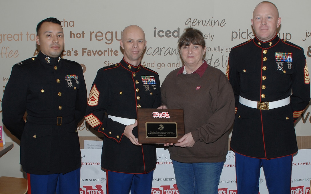 From left: Capt. Jose Castillo, I-I Inspector-Instructor; Gunnery Sgt. Johnny Ruby, coordinator, Toys for Tots; Teresa Salter, Dunkin Donuts multiunit manager, Albany and Thomasville, Ga., and 1st Sgt. James Britton, I-I first sergeant. Salter receives a plaque Tuesday from Ruby for her support during the Toys for Toys 2014 season.
Dunkin Donuts supported the Toys for Tots team by donating donuts and coffee to more than 120 Marines during a two-week period.  According to Ruby, the day the toys were distributed, the Dunkin Donuts team showed how they cared about their community and wanted to give back by helping fill bags with toys.
