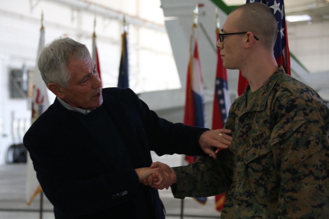 Chuck Hagel, secretary of defense, hands a coin to Lance Cpl. Andrew Pfenning, an administrative specialist with Headquarters and Headquarters Squadron, during a visit aboard Marine Corps Air Station Miramar, Calif., Jan. 13. Hagel passed out coins and took photos with Marines and Sailors after speaking to them and holding a question and answer period.