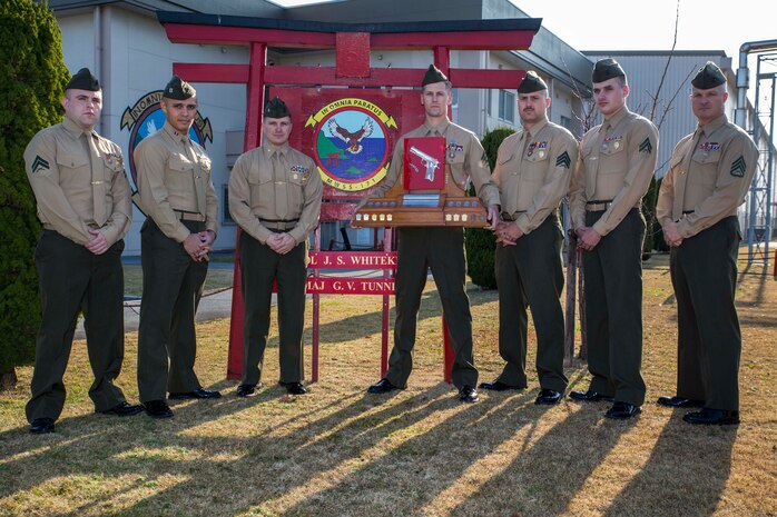 The Marine Wing Support Squadron 171 distinguished marksmen in both pistol and rifle qualifications stand in front of their squadron holding the Shively Trophy, received for winning the Far East Division Matches, Jan. 9, 2015. MWSS-171 began their shooting in Okinawa, Japan, Dec. 8, which led to a two-week culminating process of qualifying for individual awards and taking home the Shively Trophy.