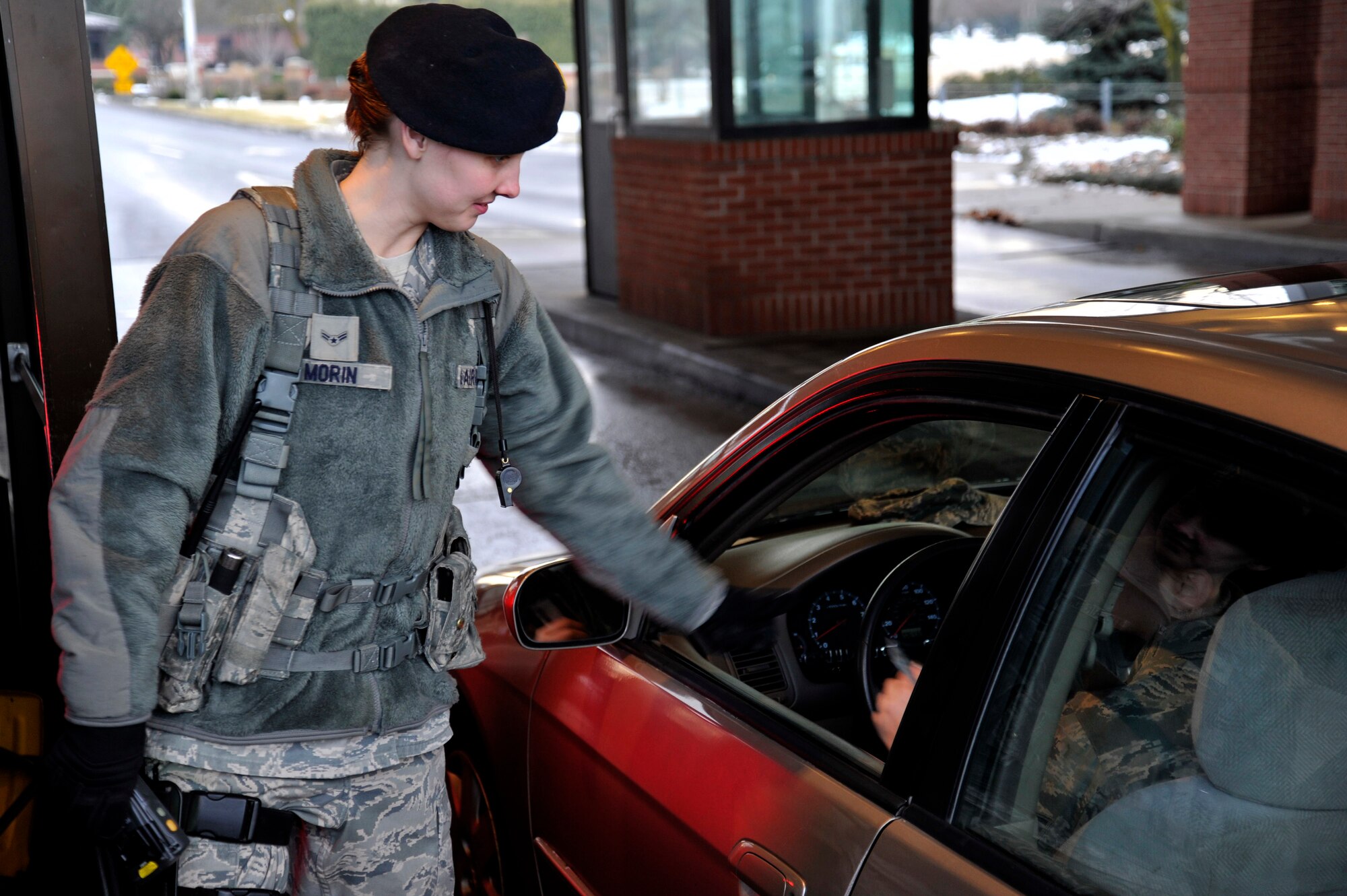 Airman 1st Class Colleen Morin, 92nd Security Forces Squadron installation entry controller, scans identification cards of people seeking access to the installation, Jan. 6, 2015, at Fairchild Air Force Base, Wash. No matter the weather conditions, the entry controllers man the front gate at all times.  (U.S. Air Force photo/Airman 1st Class Nicolo J. Daniello)
