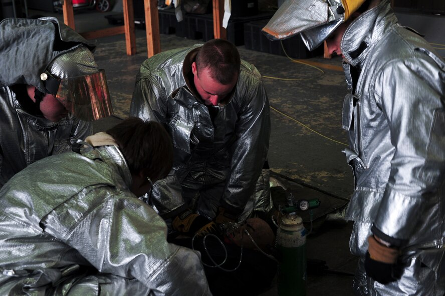 Firefighters perform a patient assessment on a manikin during a confined space extraction exercise Jan. 9, 2014, at Osan Air Base, Republic of Korea. The scenarios is designed to test firefighter's abilities to egress people from confined spaces, an essential part of their duties. (U.S. Air Force photo by Senior Airman David Owsianka)
