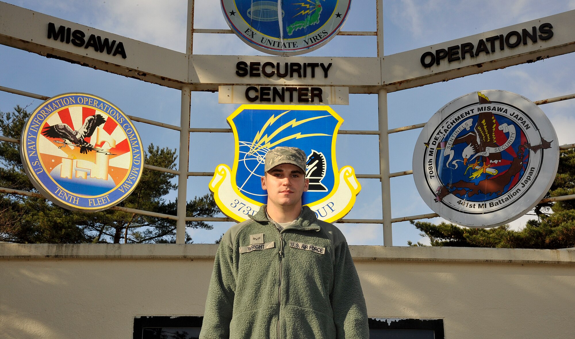 U.S. Air Force Senior Airman Jacob Wright, 373rd Support Squadron, knowledge operations management technician, poses in front of the Misawa Security Operations Center welcome sign at Misawa Air Base, Japan, Dec. 12, 2014. Along with other members of the MSOC, Wright provides communications, maintenance, and administrative support to personnel at Misawa. (U.S. Air Force photo by Airman 1st Class Patrick S. Ciccarone/Released)
