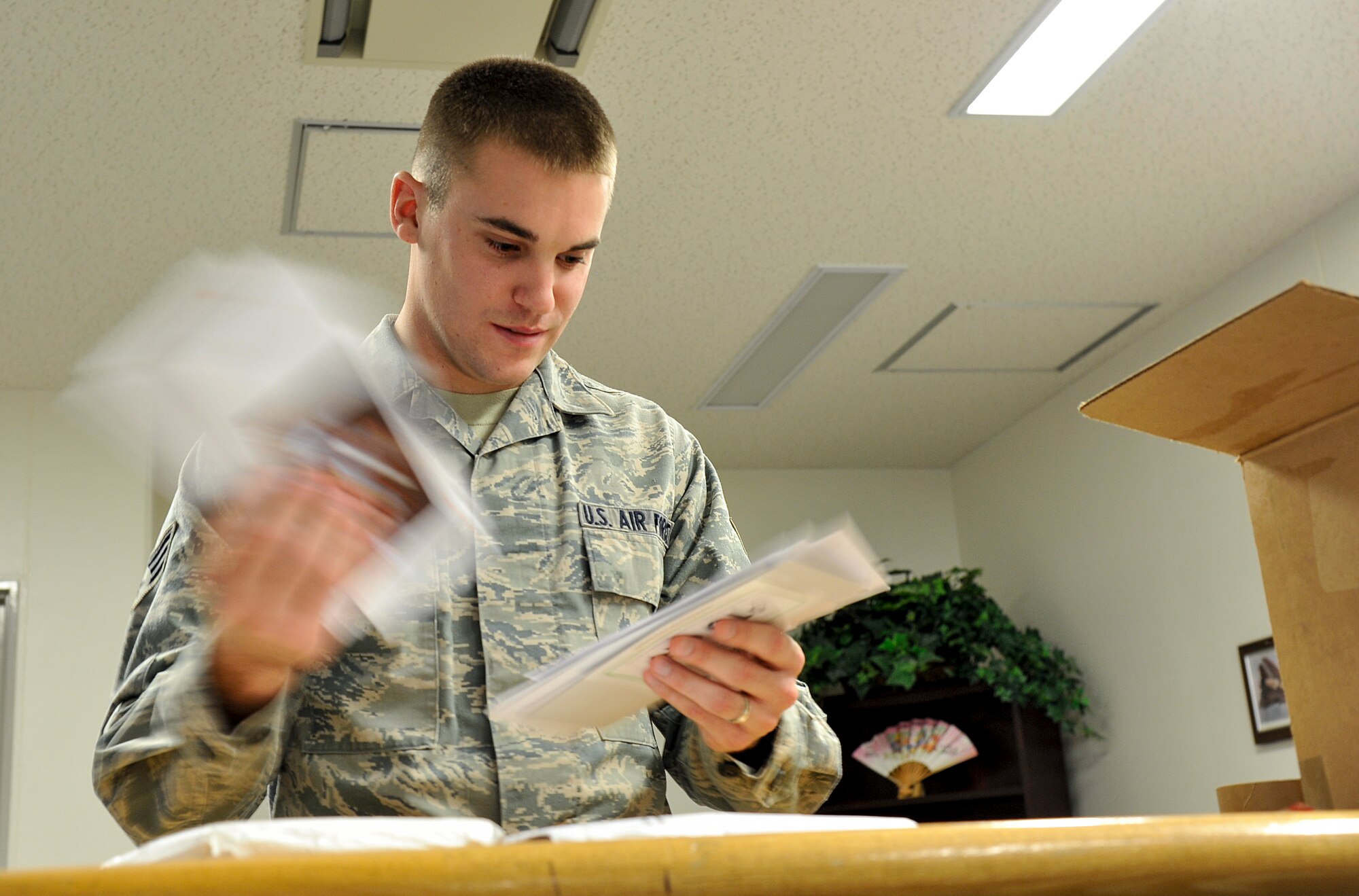 U.S. Air Force Senior Airman Jacob Wright, 373rd Support Squadron, knowledge operations management technician, sorts through mail at Misawa Air Base, Japan, Dec. 12, 2014. Among Wright’s normal operations of administrative support, he also handles incoming mail and parcels within his squadron. (U.S. Air Force photo by Airman 1st Class Patrick S. Ciccarone/Released)