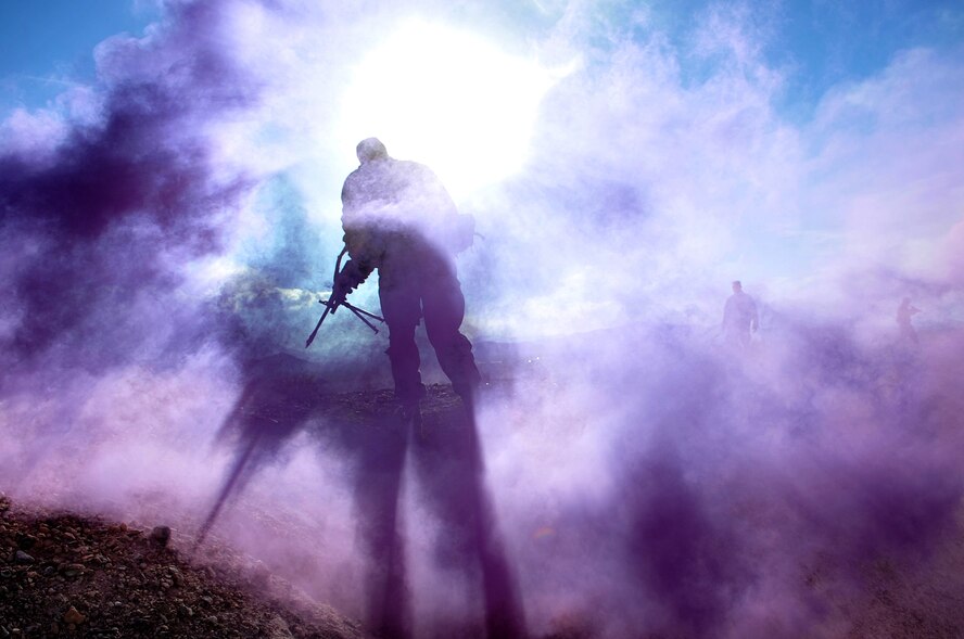 A Ranger Assessment Course student runs through smoke to return fire to simulated insurgents Oct. 10, 2014, at Silver Flag Alpha range, Nevada. RAC is the first step for Airmen who want to go to U.S. Army Ranger School. About 80 percent of Airmen who graduate RAC and go to Ranger School complete it and receive the Ranger tab. (U.S. Air Force photo by Senior Master Sgt. Cecilio Ricardo/Released)