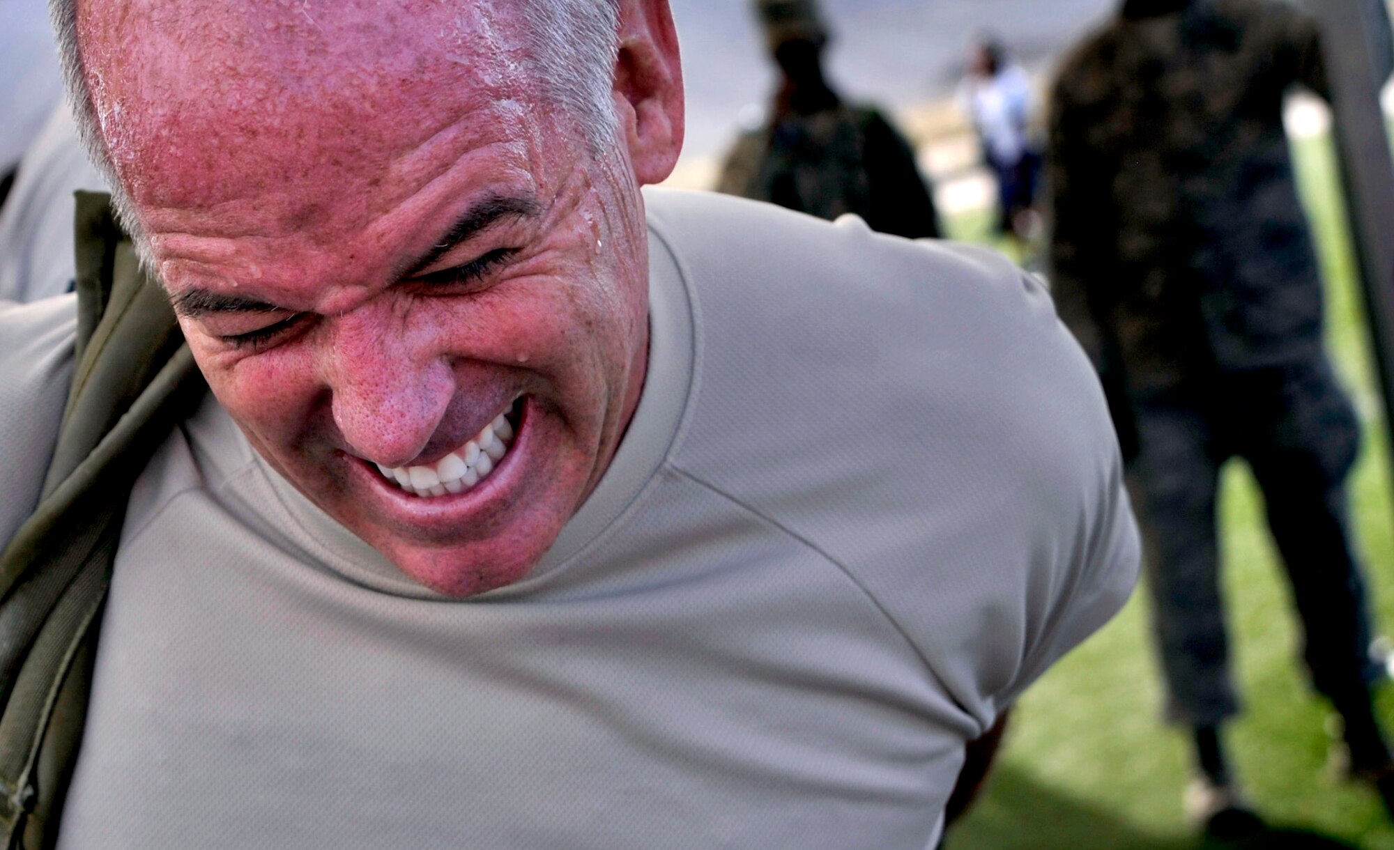 Chief Master Sgt. Butch Brien, 432nd Wing/432nd Air Expeditionary Wing Command Chief, puts on a ruck-sack before a team ruck march during the Combat Challenge July 11, 2014, at Creech Air Force Base, Nev. The Combat Challenge consisted of eight security forces-related challenges such as an M-4 Rifle breakdown and reassembly, team pull-ups, tire flips, low crawls and more. (U.S. Air Force photo by Airman 1st Class Christian Clausen/Released)