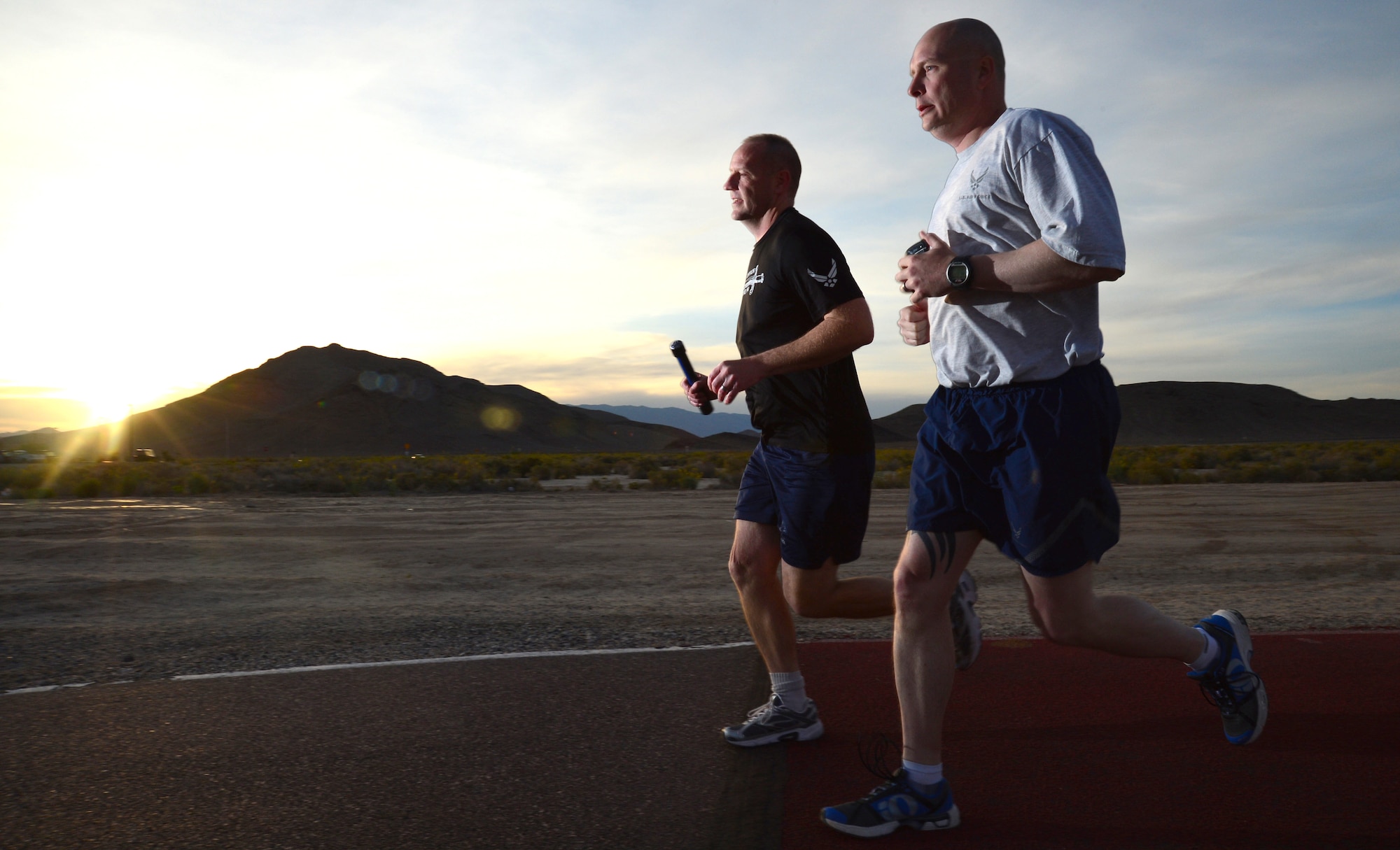 Chief Master Sgt. Paul Pohnert, left, 799th Air Base Squadron superintendent, and Master Sgt. Robert Livingston, 799th ABS first sergeant, participate in a 24-hour vigil run at Creech Air Force Base, Nev., during National Police Week May 16, 2014. Each runner carried a baton containing the names of 286 U.S. law enforcement officers who lost their lives during the past year. (U.S. Air Force photo by Tech. Sgt. Shad Eidson/Released)