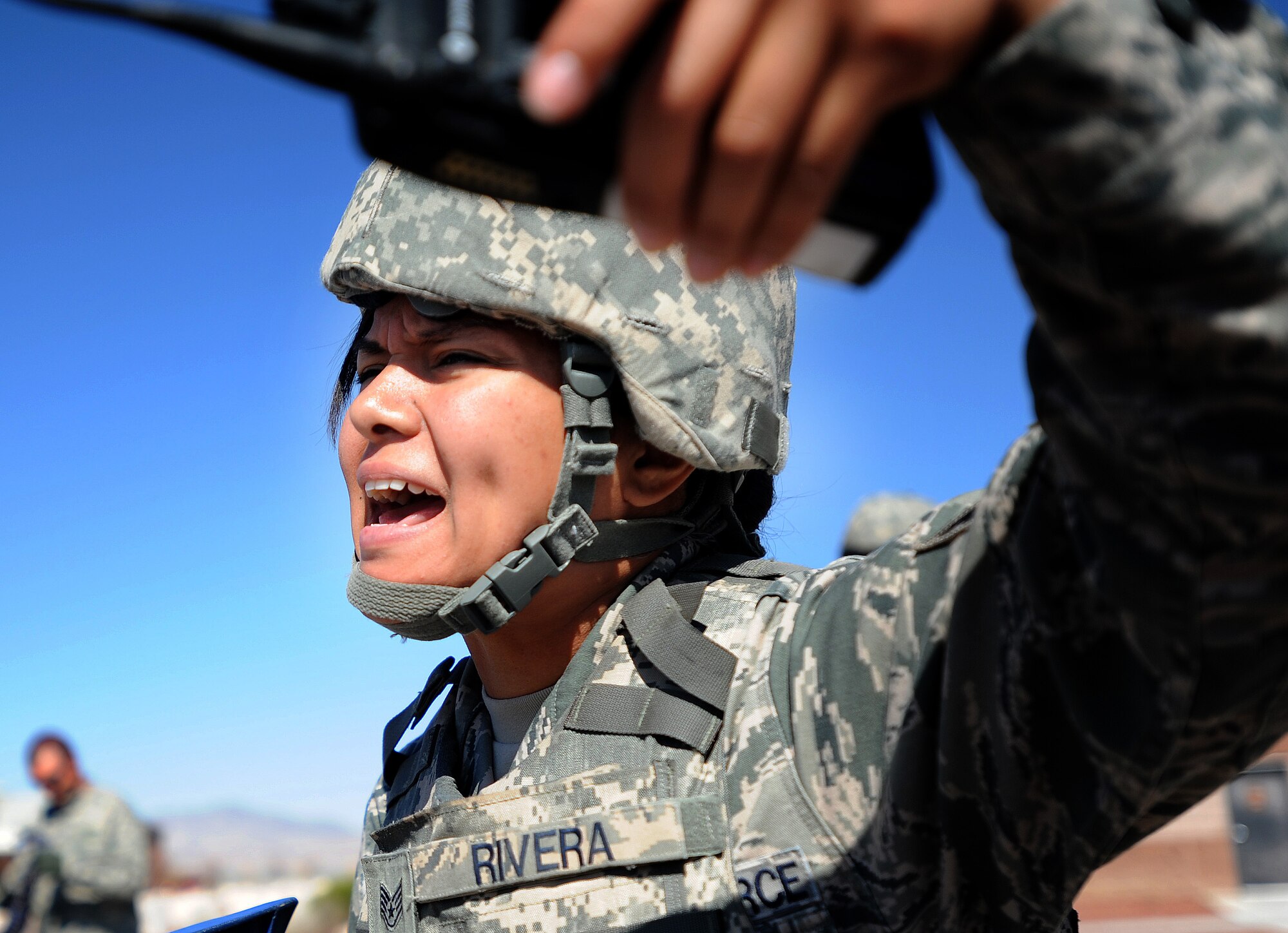 Staff Sgt. Liza Rivera, 799th Security Forces Squadron patrolman, yells to first responders during a simulated active shooter exercise at Creech Air Force Base, Nev., March 25, 2014. The scenario between Creech and Nellis Air Force Bases tested the emergency response capabilities of installation personnel, first responders and critical notification infrastructure. (U.S. Air Force photo by Senior Master Sgt. Cecilio Ricardo/Released)