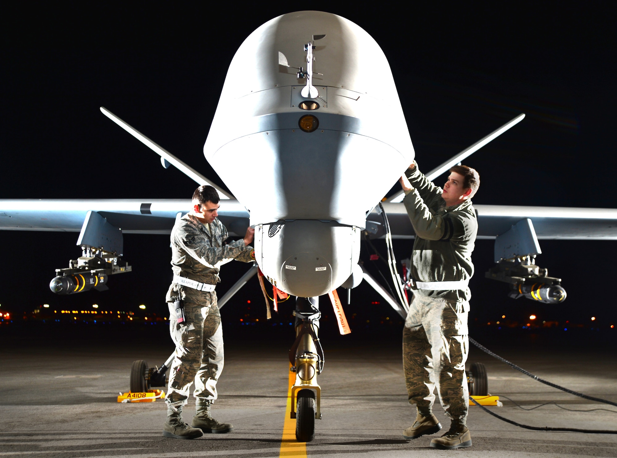 Airman 1st Class Steven, 432nd Aircraft Maintenance Squadron MQ-9 Reaper crew chief (left), and Airman 1st Class Taylor, 432nd Aircraft Maintenance Squadron MQ-9 Reaper crew chief (right), prepare an MQ-9 Reaper for flight during Combat Hammer May 15, 2014, Creech Air Force Base, Nev. Fighter, bomber and remotely piloted aircraft units around the Air Force are evaluated four times a year and provided weapons, airspace and targets from Hill AFB, Utah, or Eglin AFB, Fla. (U.S. Air Force photo by Staff Sgt. Nadine Barclay/Released)