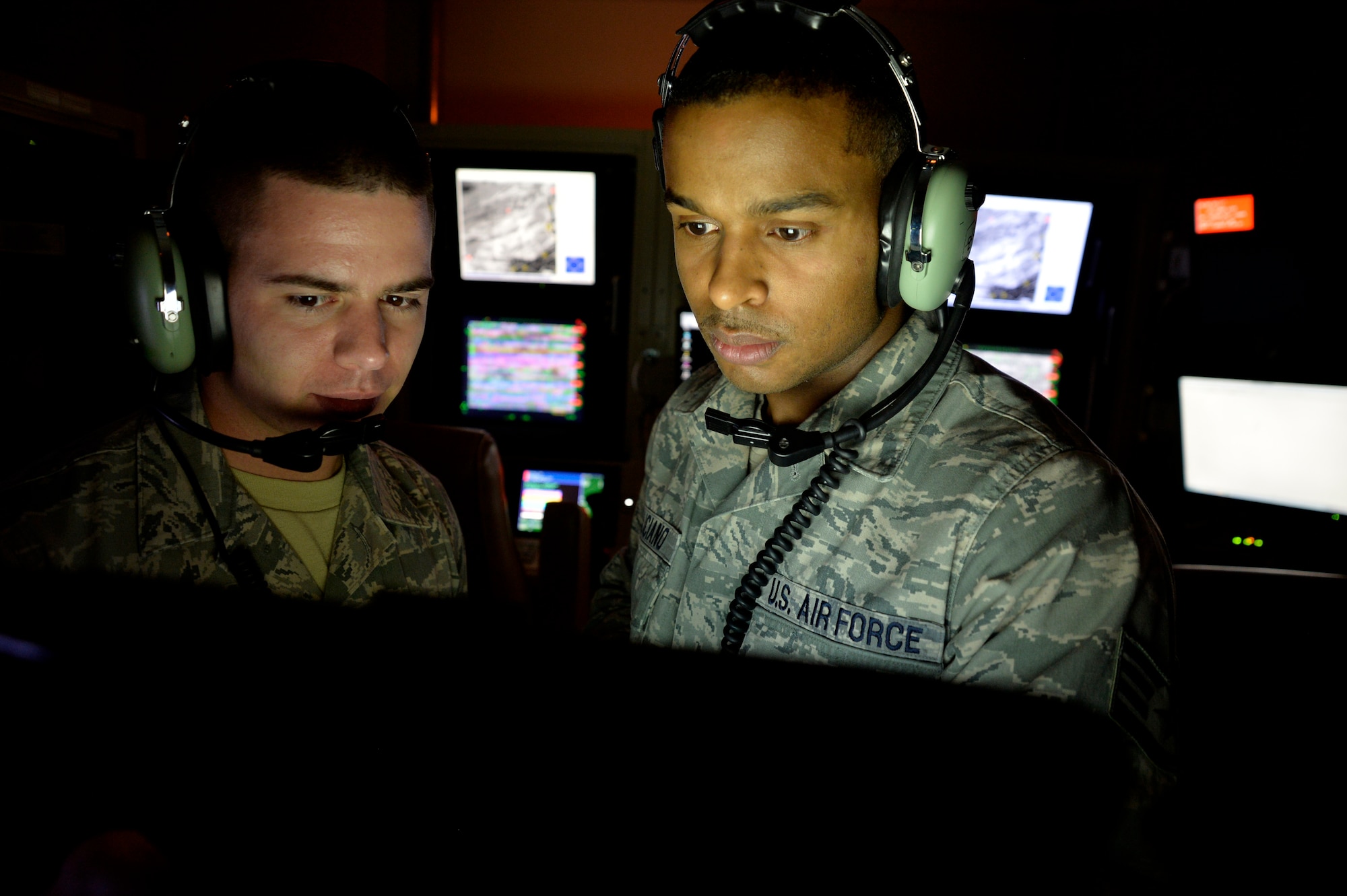 Airman First Class Ryder Luzadder, 432nd Aircraft Communications Maintenance Squadron communications technician, left, and Staff Sgt. Jose Feliciano, 432nd ACMS communications technician, look over technical orders for a ground control station May 28, 2014. The 432nd ACMS is the only squadron of its kind in the Air Force and is responsible for providing 24/7, 365-day maintenance support to the communication infrastructure that supports the wing's global remotely piloted aircraft operations. (U.S. Air Force photo by Staff Sgt. Adawn Kelsey/Released)