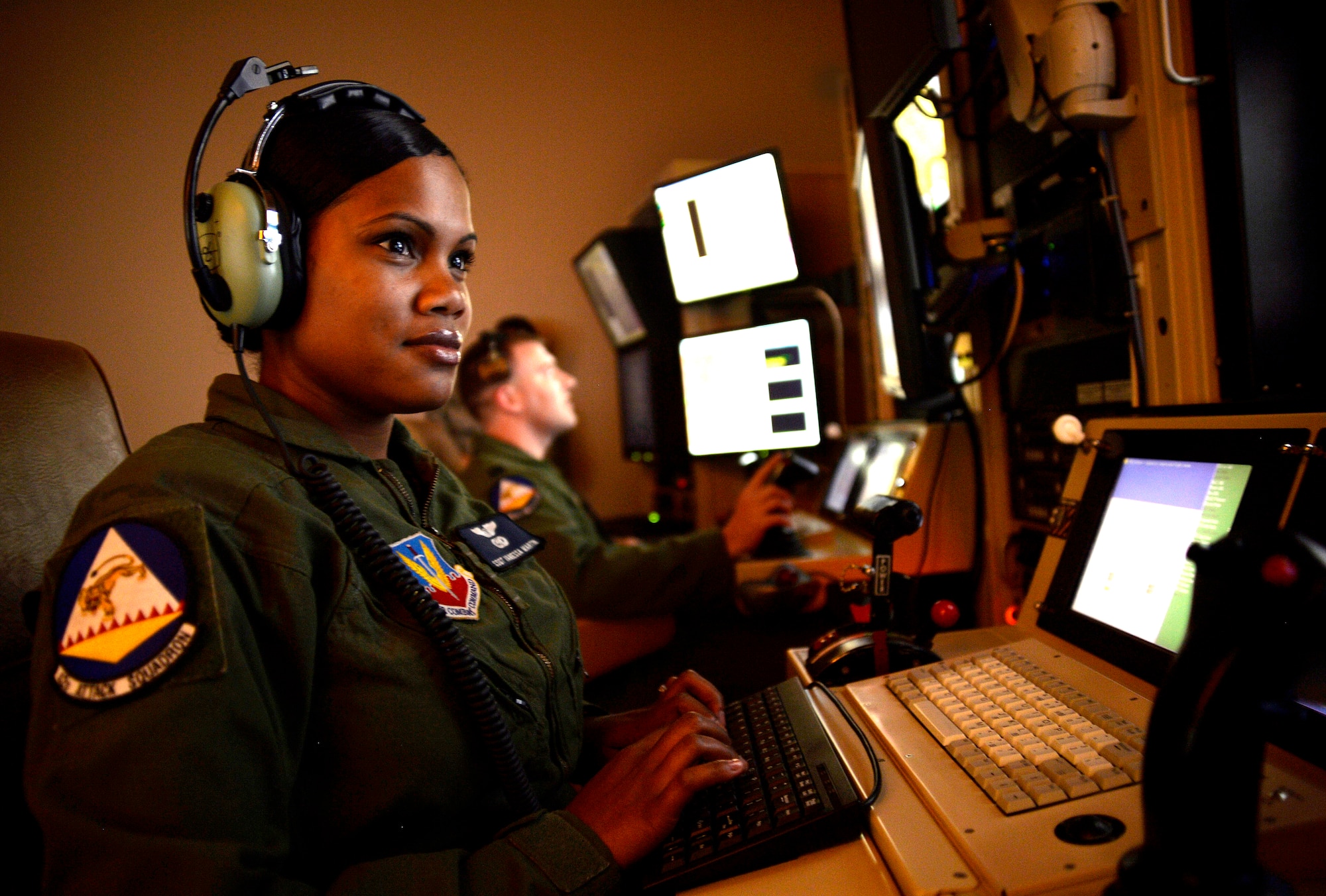 Staff Sgt. Vanessa, 42nd Attack Squadron sensor operator, front, and Capt. Andrew, 18th Reconnaissance Squadron pilot, follow a vehicle with a remotely piloted aircraft in a flight training simulator May 28, 2014. The two-person crew was selected to fly the 65th air combat patrol, an initiative set by then Secretary of Defense Robert Gates Dec. 23, 2009 (Last names have been withheld for security purposes). (U.S. Air Force photo by Staff Sgt. Adawn Kelsey/Released)