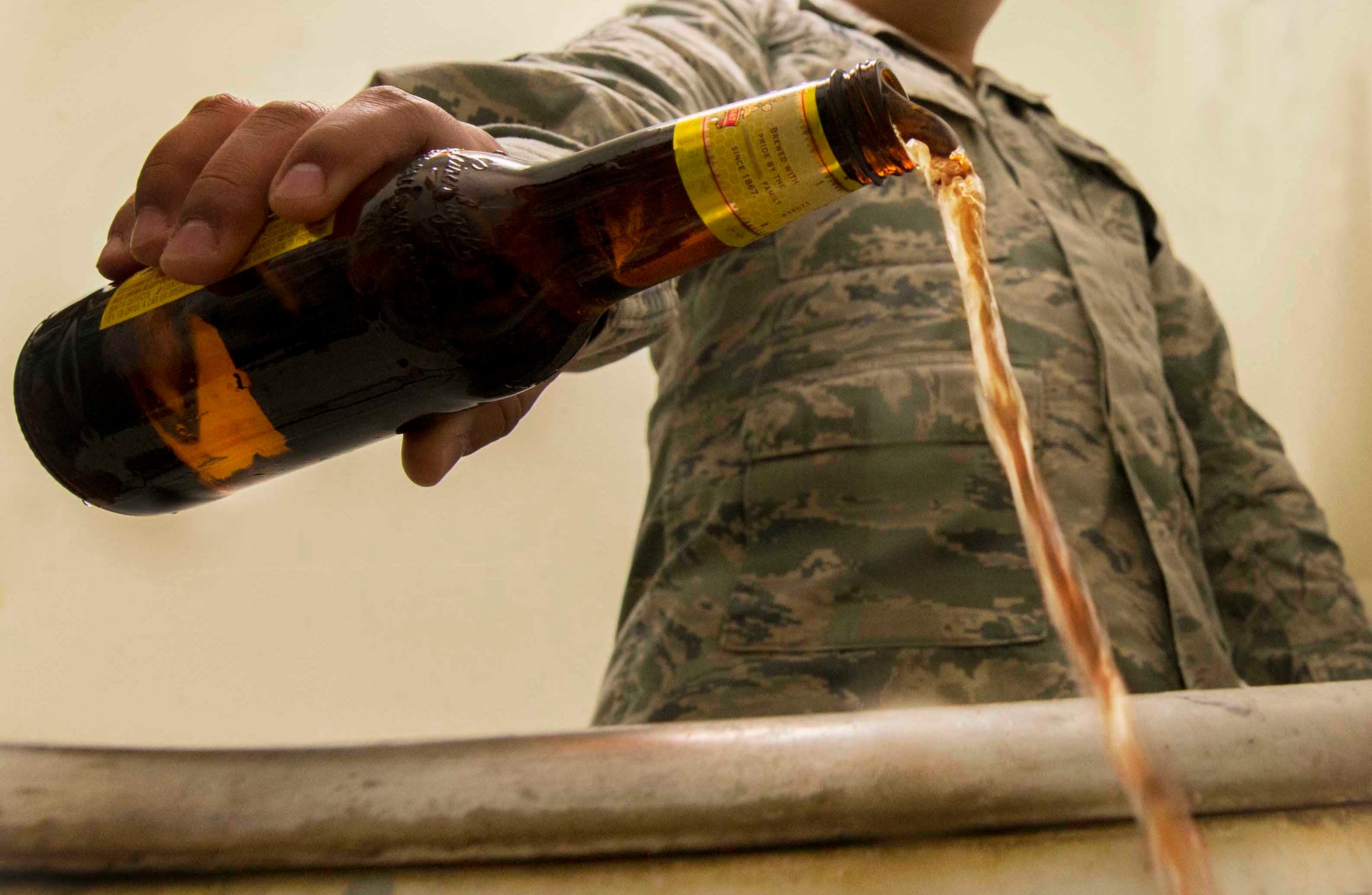 Airman 1st Class Carlos D. Muñoz, 91st Missile Maintenance Squadron facilities maintenance technician, pours a drink down the drain to represent his recovery from excessive drinking while stationed on Minot Air Force Base, N.D. (U.S. Air Force photo illustration/ Airman 1st Class Sahara. L. Fales)
