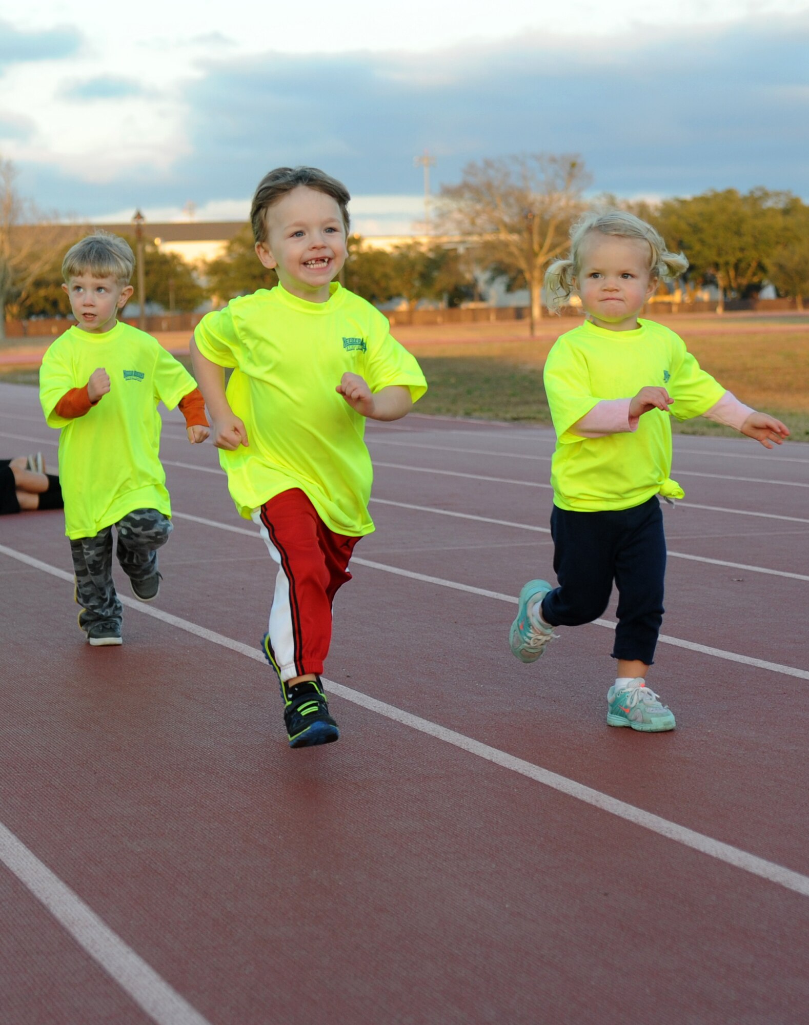 The children of Lt. Col. James Coughlin, 85th Engineering Installation Squadron commander; Capt. Jered Beaird, 81st Surgical Operations Squadron operating room clinical nurse, and Capt. Matthew Moberg, 81st Dental Squadron residency general dentist, run during the Keesler Dragons Family Running Club practice Jan. 12, 2015, at the Triangle Track, Keesler Air Force Base, Miss.  More than 25 families participate in the running club. The club is free to anyone with access to base. The club has three running categories: Little Dragons- Ages 0-5; Medium Dragons- Ages 6-8; and Big Dragons- Ages 9 and up. The club meets on Mondays and Wednesdays at 4:30 p.m. (U.S. Air Force photo by Kemberly Groue)