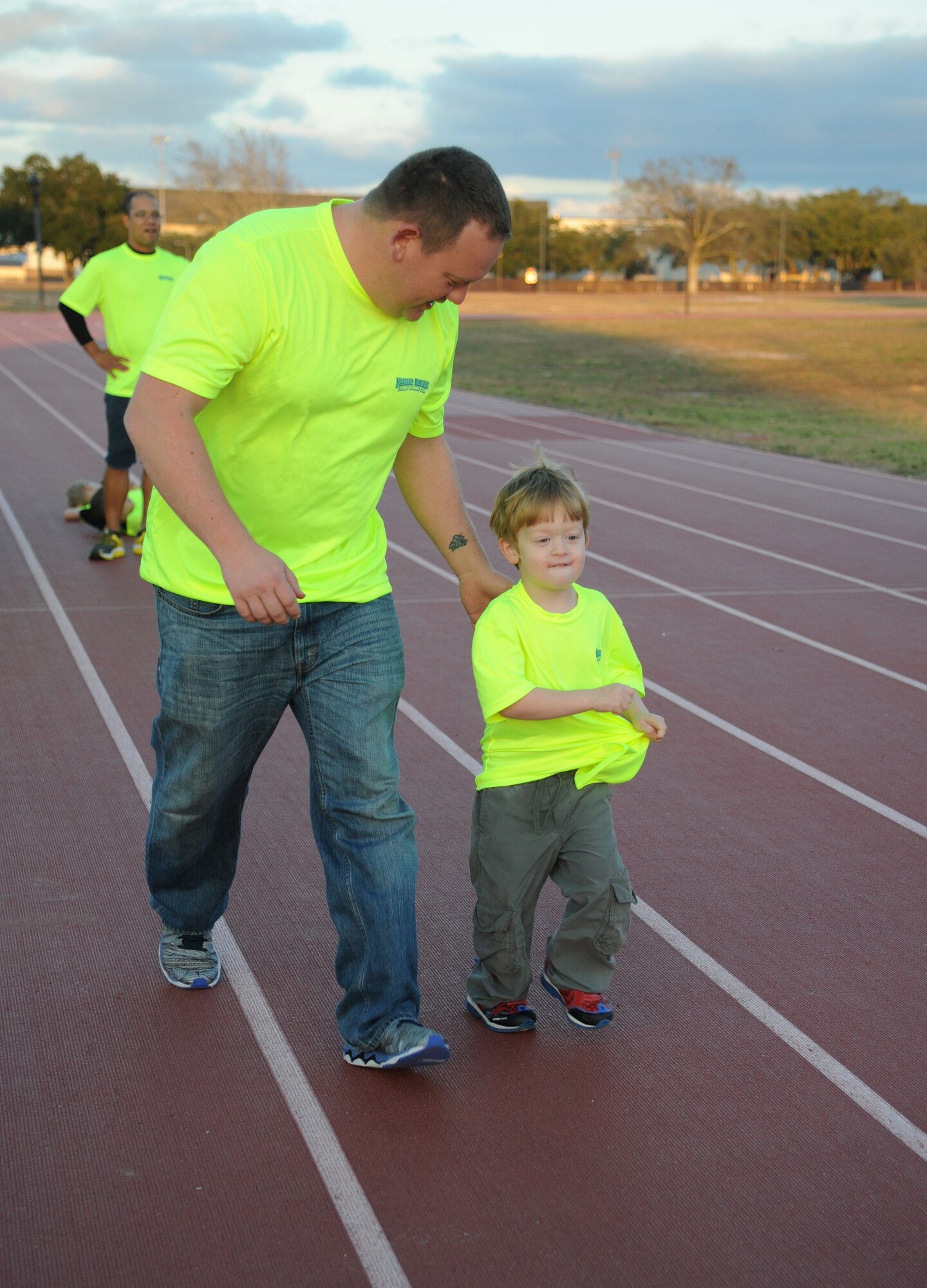 Tech. Sgt. Robert Conger, 85th Engineering Installation Squadron quality assurance NCOIC, and his son run during the Keesler Dragons Family Running Club practice Jan. 12, 2015, at the Triangle Track, Keesler Air Force Base, Miss. More than 25 families participate in the running club. The club is free to anyone with access to base. The club has three running categories: Little Dragons- Ages 0-5; Medium Dragons- Ages 6-8; and Big Dragons- Ages 9 and up. The club meets on Mondays and Wednesdays at 4:30 p.m. (U.S. Air Force photo by Kemberly Groue)