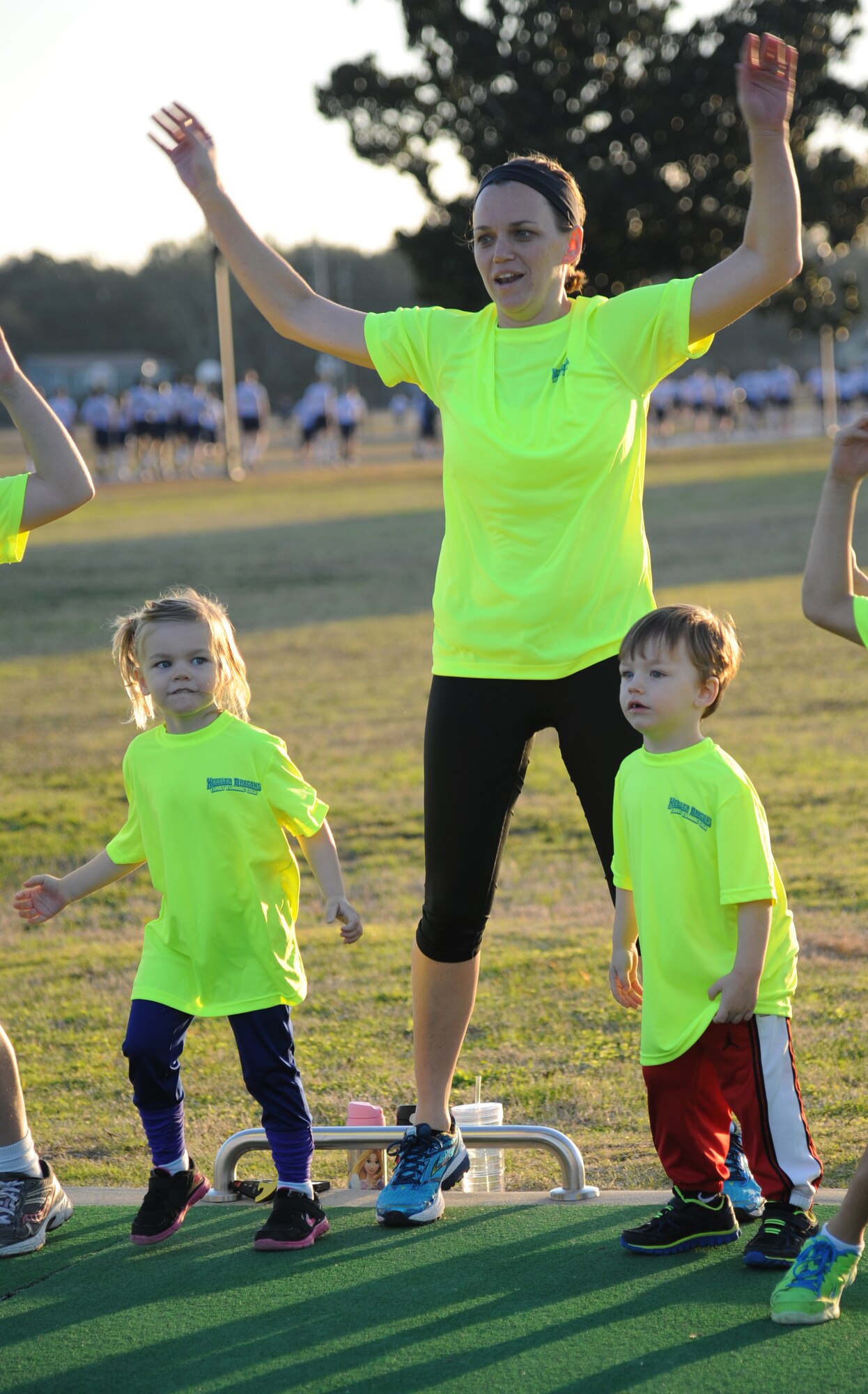 The family of Capt. Jered Beaird, 81st Surgical Operations Squadron operating room clinical nurse, participates in warm-up exercises during the Keesler Dragons Family Running Club practice Jan. 12, 2015, at the Triangle Track, Keesler Air Force Base, Miss.  More than 25 families participate in the running club. The club is free to anyone with access to base. The club has three running categories: Little Dragons- Ages 0-5; Medium Dragons- Ages 6-8; and Big Dragons- Ages 9 and up. The club meets on Mondays and Wednesdays at 4:30 p.m. (U.S. Air Force photo by Kemberly Groue)