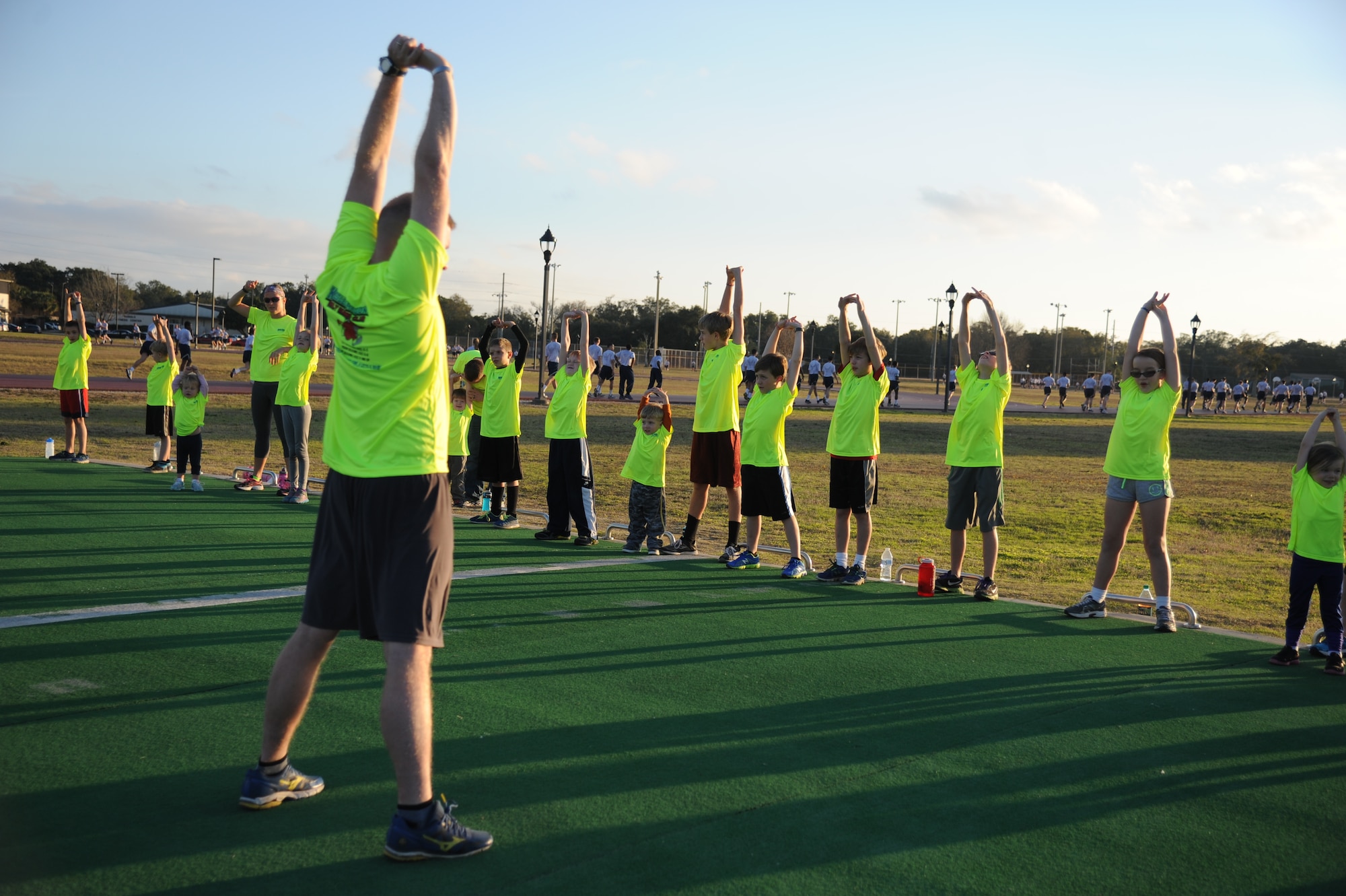 Lt. Col. James Coughlin, 85th Engineering Installation Squadron commander, conducts warm-up exercises during the Keesler Dragons Family Running Club practice Jan. 12, 2015, at the Triangle Track, Keesler Air Force Base, Miss.  More than 25 families participate in the running club. The club is free to anyone with access to base. The club has three running categories: Little Dragons- Ages 0-5; Medium Dragons- Ages 6-8; and Big Dragons- Ages 9 and up. The club meets on Mondays and Wednesdays at 4:30 p.m. (U.S. Air Force photo by Kemberly Groue)