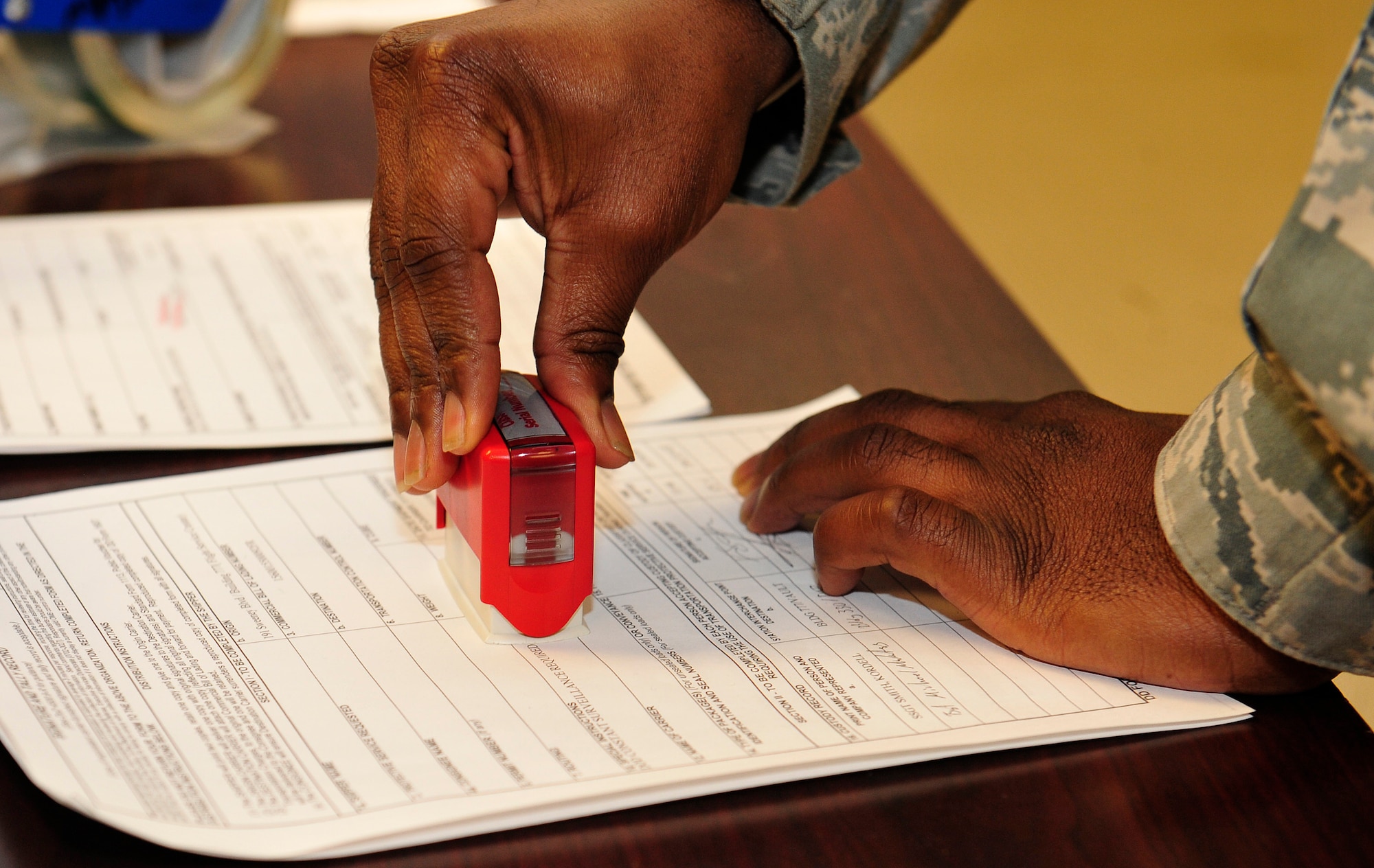 U.S. Air Force Staff Sgt. Kordell Smith, 633rd Logistics Readiness Squadron flight service center supervisor, stamps a form at Langley Air Force Base, Va., Jan. 13, 2015. Smith, along with all flight service center Airmen, are responsible for tracking, inspecting and verifying aircraft. (U.S. Air Force photo by Airman 1st Class Breonna Veal/Released) 