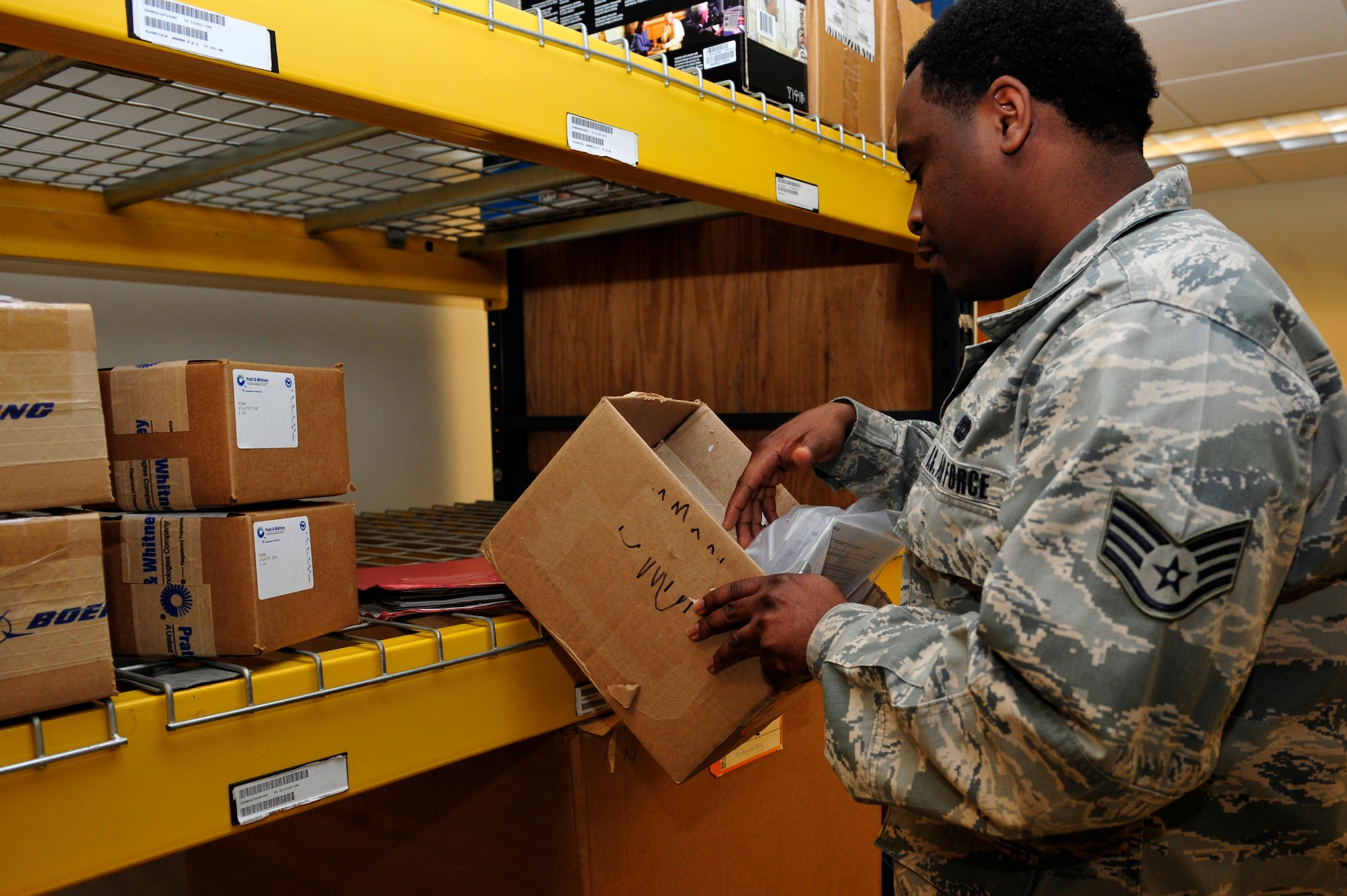 U.S. Air Force Staff Sgt. Kordell Smith, 633rd Logistics Readiness Squadron flight service center supervisor, fills a part order at Langley Air Force Base, Va., Jan. 13, 2015. The flight service center receives various parts that are unable to be fixed on base, and broken parts of aircraft before being sent off base for maintenance or repair. (U.S. Air Force photo by Airman 1st Class Breonna Veal/Released) 