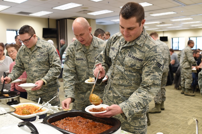 Airmen scoop chili into bowls during the chili cook-off held at the Buckley Chapel Jan. 7, 2015, on Buckley Air Force Base, Colo. Categories for judging included red, green, white, vegetarian, hot and overall chili, with each winner receiving a $20 gift card. (U.S. Air Force photo by Airman 1st Class Samantha Saulsbury/Released) 