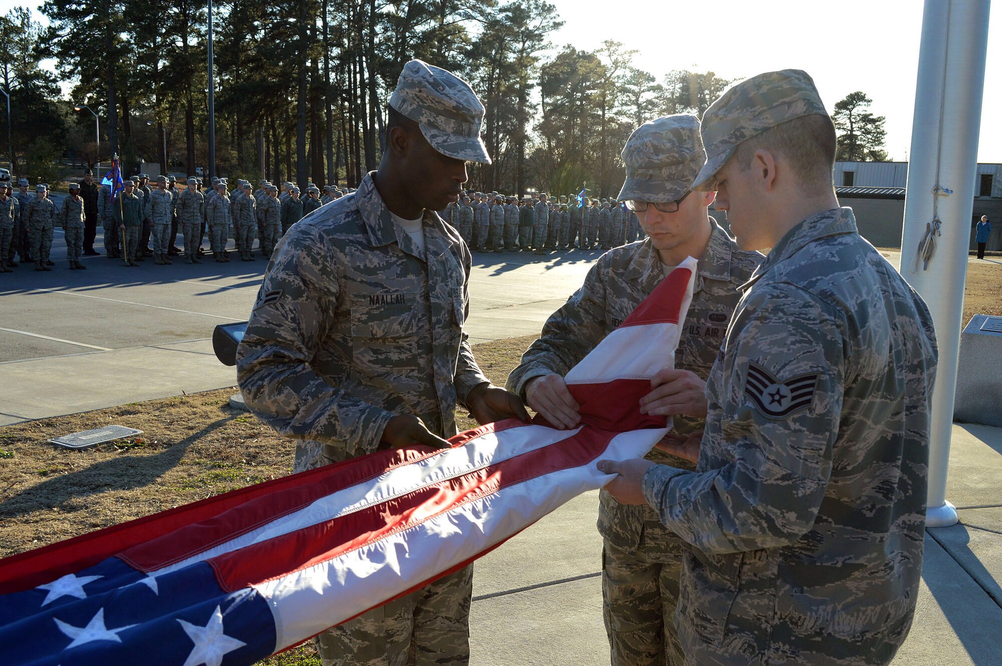 Pope Field Honor Guard Team members, Air Force Airman 1st Class Alio Naallah, left, Senior Airman Erik Heiss, middle, and Staff Sgt. John Wildey, right, fold the U.S. flag during a 43rd Airlift Group retreat ceremony held at the Pope Field flagstaff on Jan. 9, Pope Army Airfield, North Carolina. Retreat, the retirement of the colors from the day's activities, is a ceremony in which the unit honors the U.S. flag when it is lowered in the evening. (U.S. Air Force photo/Marvin Krause)