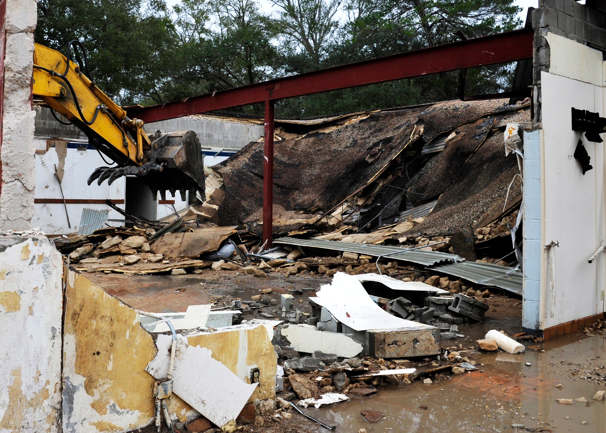 Personnel from the 96th Civil Engineer Group operate a demolition excavator to tear down Bldg. 606 in the former Federal Prison Camp compound at Eglin Air Force Base, Fla. on Jan. 12. The 24,529 square foot building was the dining facility for the inmates and guards and has been vacant since 2005. This building is considered excess, beyond economic repair and not usable. Demolition is estimated to be complete by the end of January. (U.S. Air Force photo/Ilka Cole)