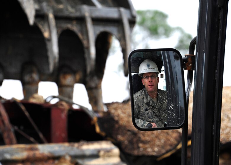 Chief Master Sgt.Bryan Creager, 96th Test Wing command chief, operates a demolition excavator to tear down Bldg. 606 in the former Federal Prison Camp compound at Eglin Air Force Base, Fla. on Jan. 12. The 24,529 square foot building was the dining facility for the inmates and guards and has been vacant since 2005. This building is considered excess, beyond economic repair and not usable. Demolition is estimated to be complete by the end of January. (U.S. Air Force photo/Ilka Cole) 
