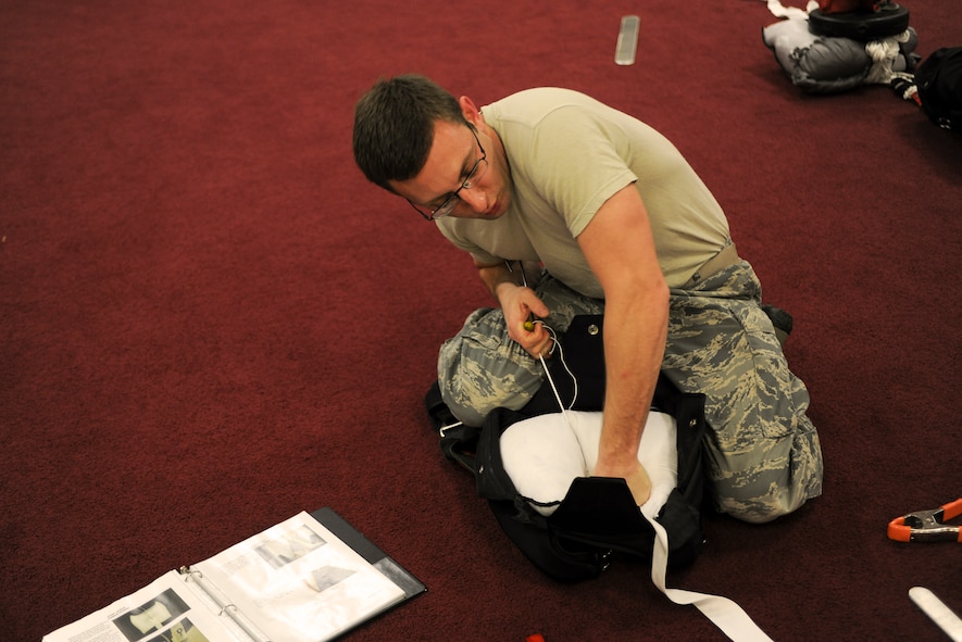 U.S. Air Force Senior Airman Mason Bengston, 38th Rescue Squadron aircrew flight equipment craftsman, conducts closing procedures on a Pararescue Advanced Parachute System Reserve canopy Jan. 12, 2015, at Moody Air Force Base, Ga. AFE Airmen check parachutes for defects and damage to ensure their airworthiness. (U.S. Air Force photo by Senior Airman Sandra Marrero/Released)
