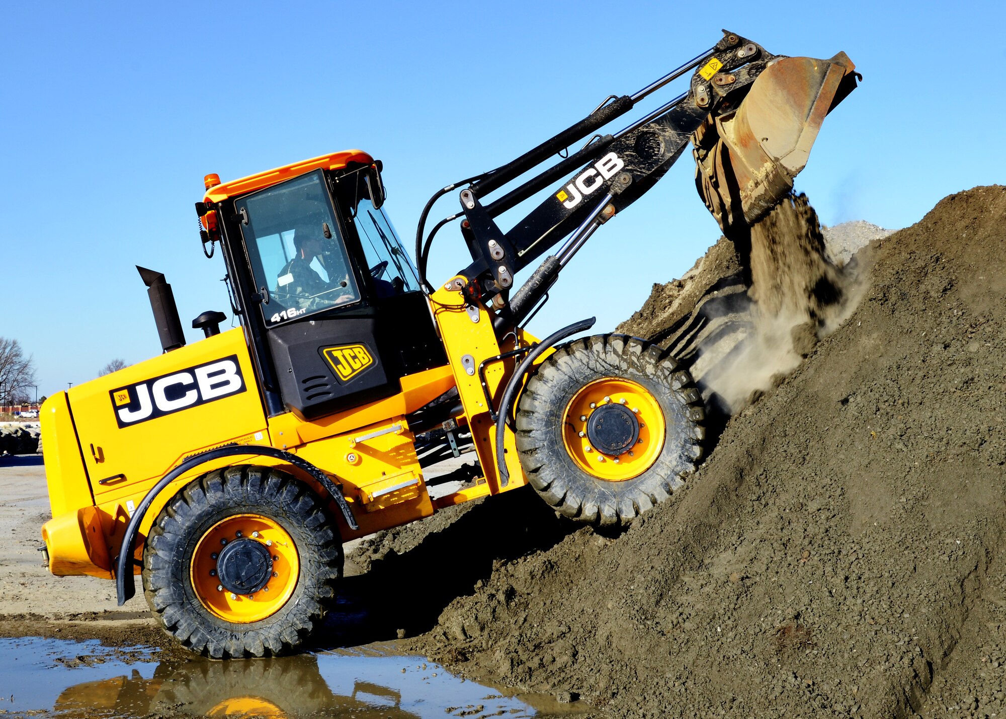 U.S. Air Force Airman 1st Class Brandon Ritenour, 633rd Civil Engineer Squadron heavy equipment operator, empties a loader at Langley Air Force Base, Va., Jan. 9, 2015. Heavy equipment operators are often referred to as “Dirt Boys” because of the messy nature of their job. Ritenour said “Dirt Boy” is a term of endearment he takes pride in, because it signifies the hard work he and his team put into making the mission possible. (U.S. Air Force photo by Airman 1st Class Devin Scott Michaels/Released)