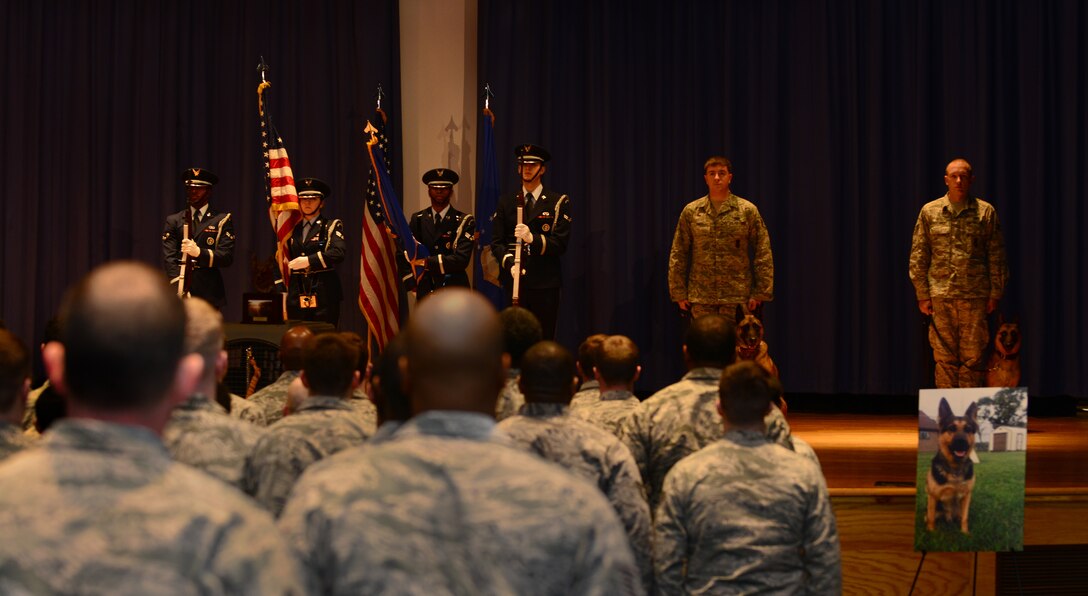 U.S. Air Force Airmen stand at attention as Joint Base Langley-Eustis honor guardsmen present the colors during a military working dog memorial ceremony at Langley Air Force Base, Va., Jan. 8, 2015. The ceremony honored the life and career of Erdo M614, former 633rd Security Forces Military Working Dog. (U.S. Air Force photo by Staff Sgt. Natasha Stannard/Released)