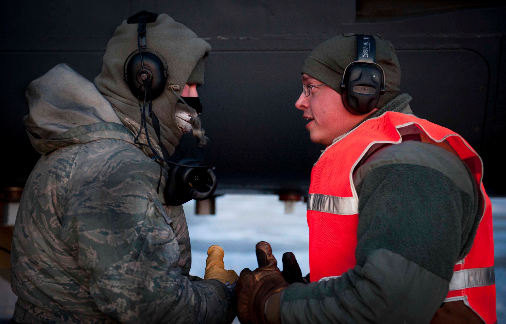 Senior Airman Taylor Lancaster, 5th Aircraft Maintenance Squadron aircraft crew chief, speaks to a maintenance Airman on Minot Air Force Base, N.D., Jan. 9, 2014. Lancaster’s main duty as a crew chief is to ensure his jet is fixed and prepared to take off before its flight time. (U.S. Air Force photo/Airman 1st Class Sahara L. Fales)