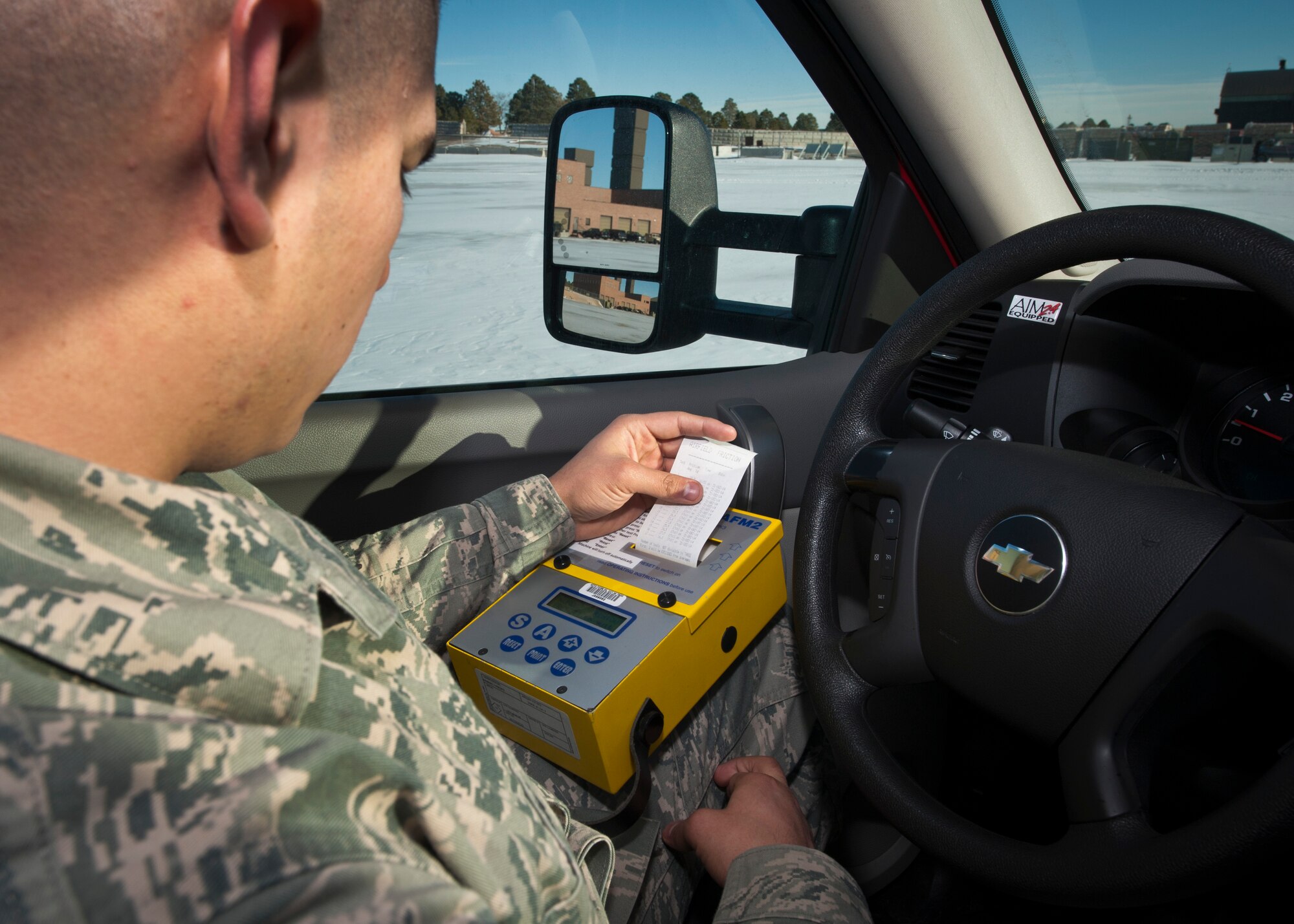 PETERSON AIR FORCE BASE, Colo. – Airman 1st Class Jesus Vera, 21st Operations Support Squadron airfield management shift lead, reads a printout from a Bowmonk AFM2 airfield friction meter after testing the braking conditions of the apron Dec. 31, 2014. Airfield management is responsible for the safety of all incoming and outgoing aircraft and their crews, ranging from inspecting and maintaining the runways, taxiways and aprons of the airfield to responding to in-flight emergencies and coordinating with other base agencies to make aircrews’ stays as efficient as possible. (U.S. Air Force photo by Airman 1st Class Rose Gudex)