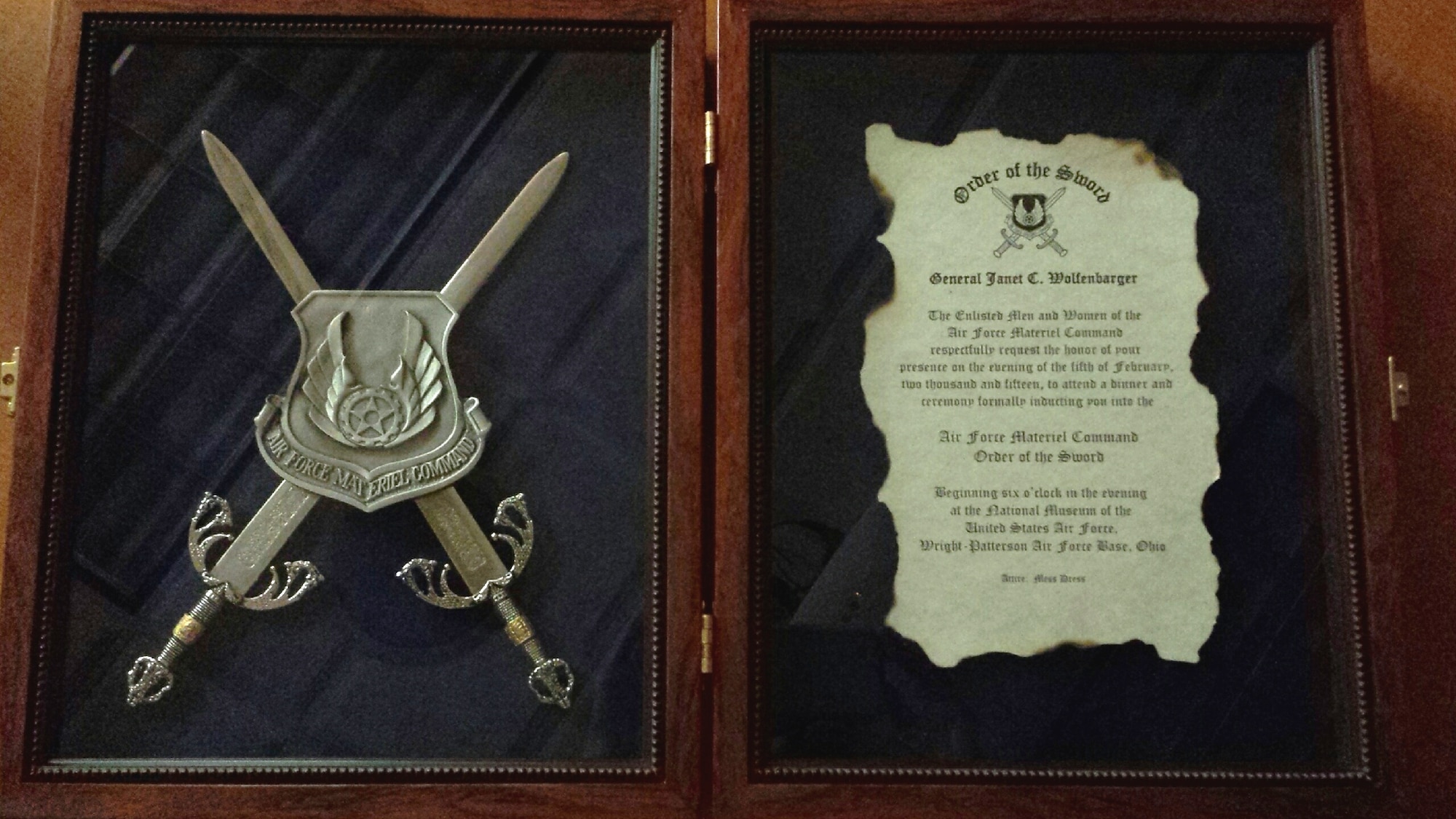 The formal invitation to the Order of the Sword induction ceremony for Gen. Janet Wolfenbarger, Air Force Materiel Command commander. Wolfenbarger was surprised with the notification of her induction on Sept. 3, 2014. This formal invitation was also a surprise, presented by Chief Master Sgt. Michael Warner, AFMC command chief, at the end of a brown-bag lunch session with the headquarters AFMC chief master sergeants. Wolfenbarger's induction ceremony is scheduled for Feb. 5, 2015, at the National Museum of the United States Air Force. (U.S. Air Force photo)