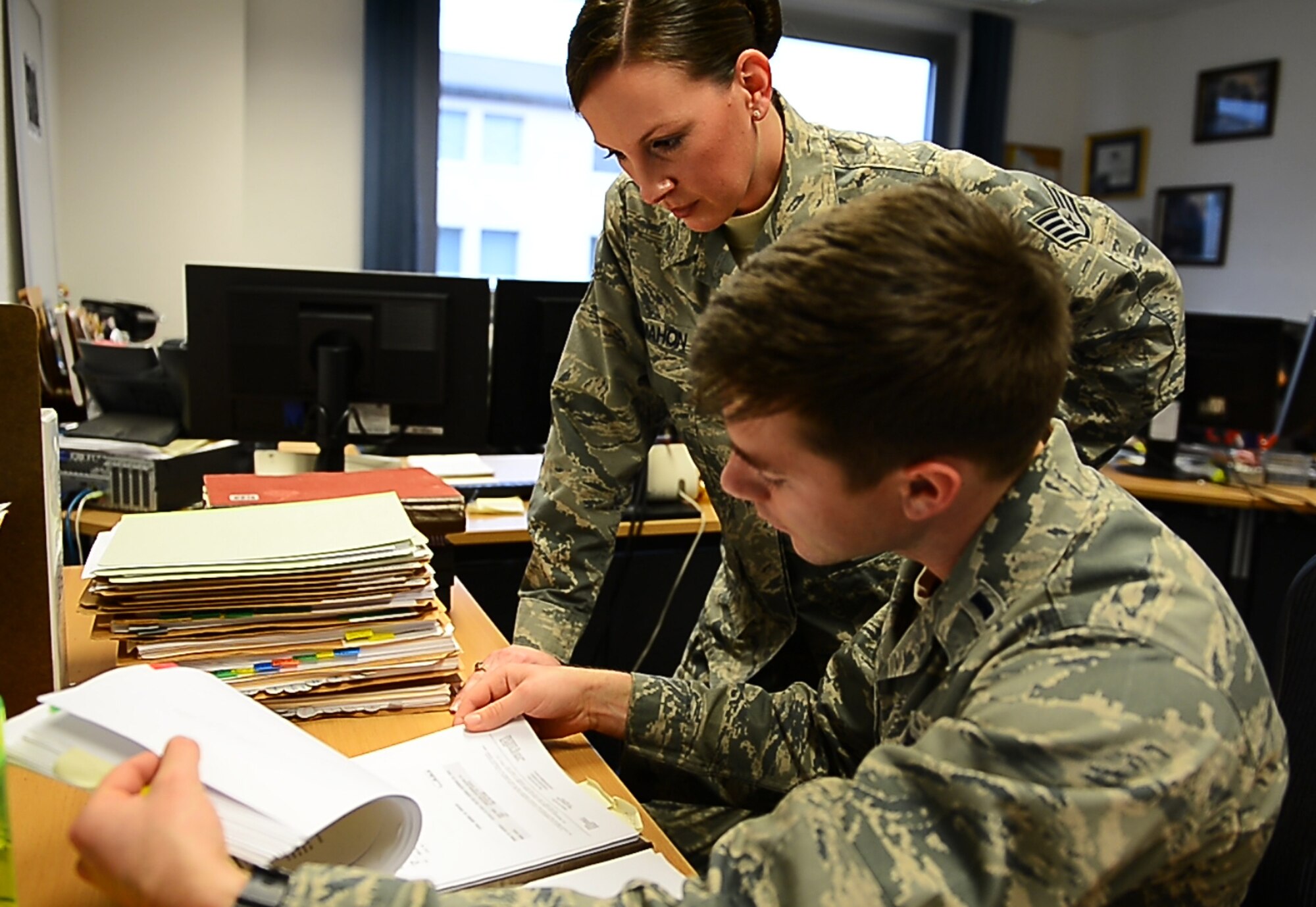 (Left) Staff Sgt. Katie McMahon, 700th Contracting Squadron contracting officer, and 1st Lt. Matthew Bogan, 700th CONS contracting officer, review a contract at Kapaun Air Station, Germany, Dec. 16, 2014. McMahon and Bogan work with other contracting officers to ensure Airmen have the resources necessary to complete any mission. (U.S. Air Force photo by Senior Airman Armando A. Schwier-Morales)  