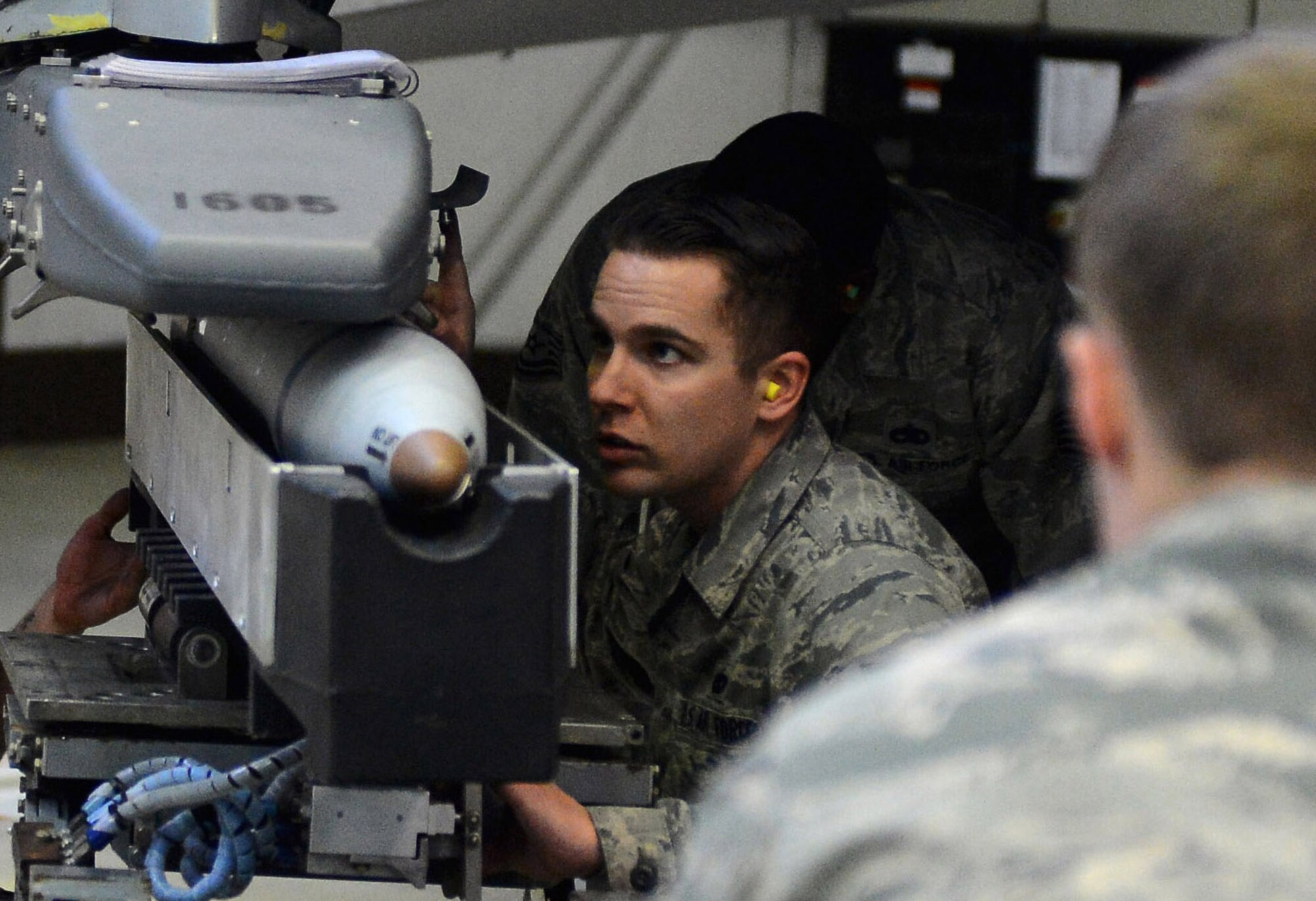 Airmen from the 52nd Aircraft Maintenance Squadron work together aligning a missile during a weapons load competition in Hangar 1 at Spangdahlem Air Base, Germany, Jan. 9, 2015. Load teams consisted of three Airmen who performed multiple tasks to complete the competition. (U.S. Air Force photo by Airman 1st Class Luke Kitterman/Released)  