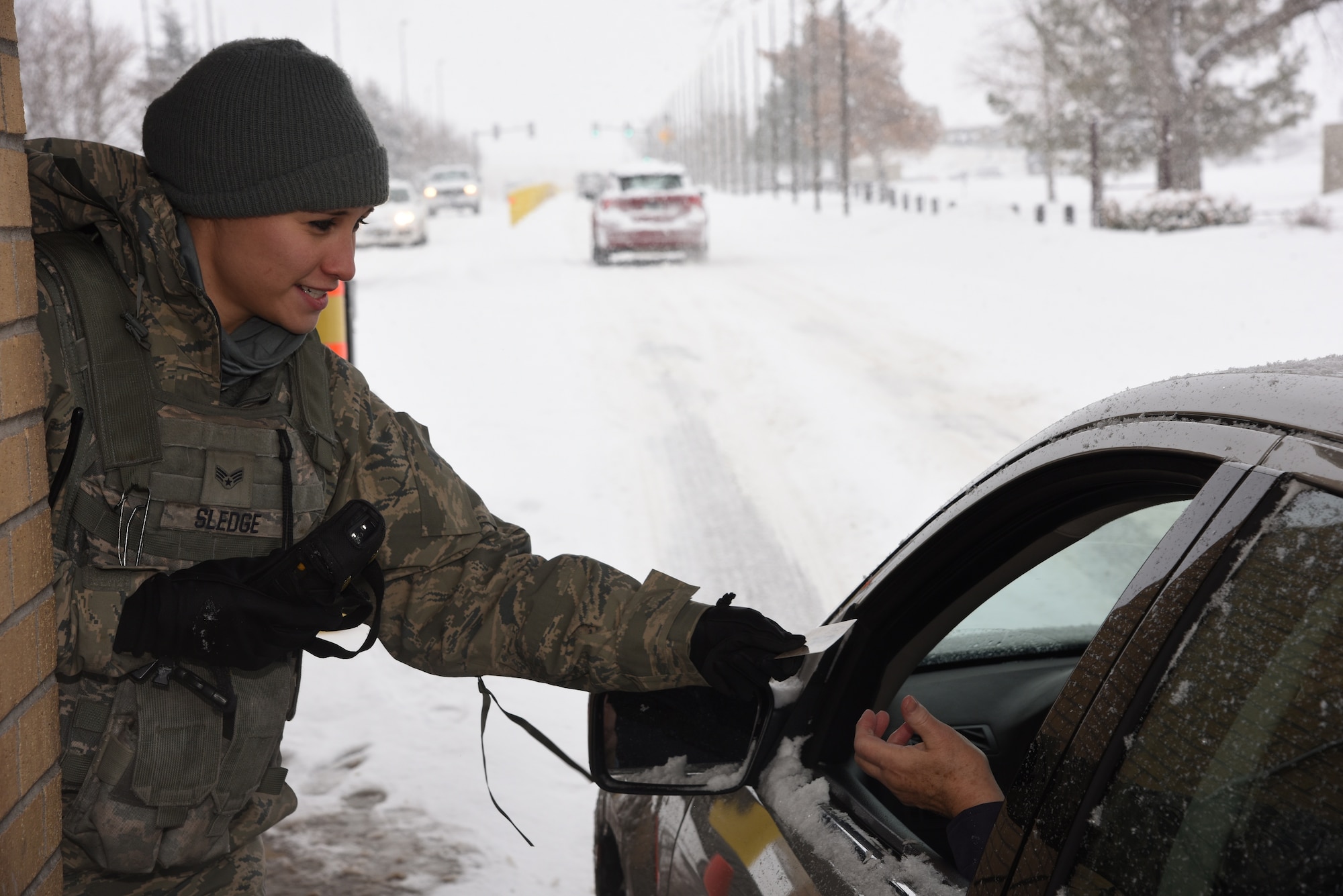 Senior Airman Kayla Sledge, 341st Security Forces Squadron member, checks military identification cards at Malmstrom Air Force Base’s main gate Jan. 6. During her 12-hour shift, Sledge and her team members are responsible for security checks, vehicle searches and ensuring only eligible military and civilian personnel are allowed on the instillation. (U.S. Air Force photo/Airman 1st Class Dillon Johnston) 