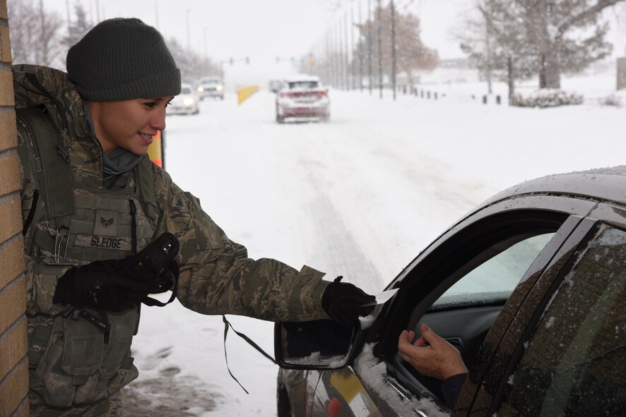 Senior Airman Kayla Sledge, 341st Security Forces Squadron member, checks military identification cards at Malmstrom Air Force Base’s main gate Jan. 6. During her 12-hour shift, Sledge and her team members are responsible for security checks, vehicle searches and ensuring only eligible military and civilian personnel are allowed on the instillation. (U.S. Air Force photo/Airman 1st Class Dillon Johnston) 