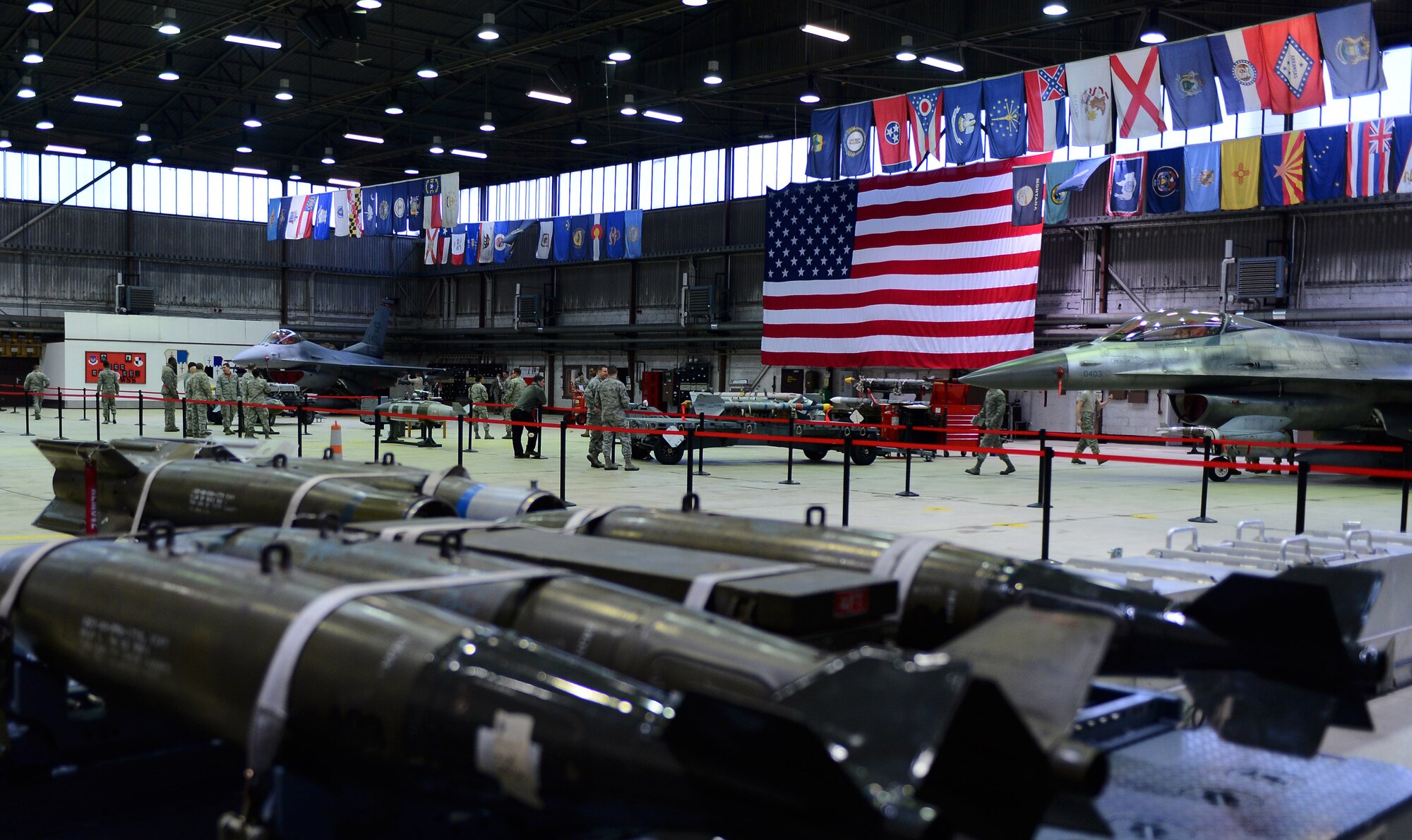 Airmen from the 52nd Aircraft Maintenance Squadron prepare two F-16 Fighting Falcon fighter aircraft before the start of a weapons load competition in Hangar 1 at Spangdahlem Air Base, Germany, Jan. 9, 2015. The four teams in the competition were the weapons load competition quarterly winners of 2014. (U.S. Air Force photo by Airman 1st Class Luke Kitterman/Released)  