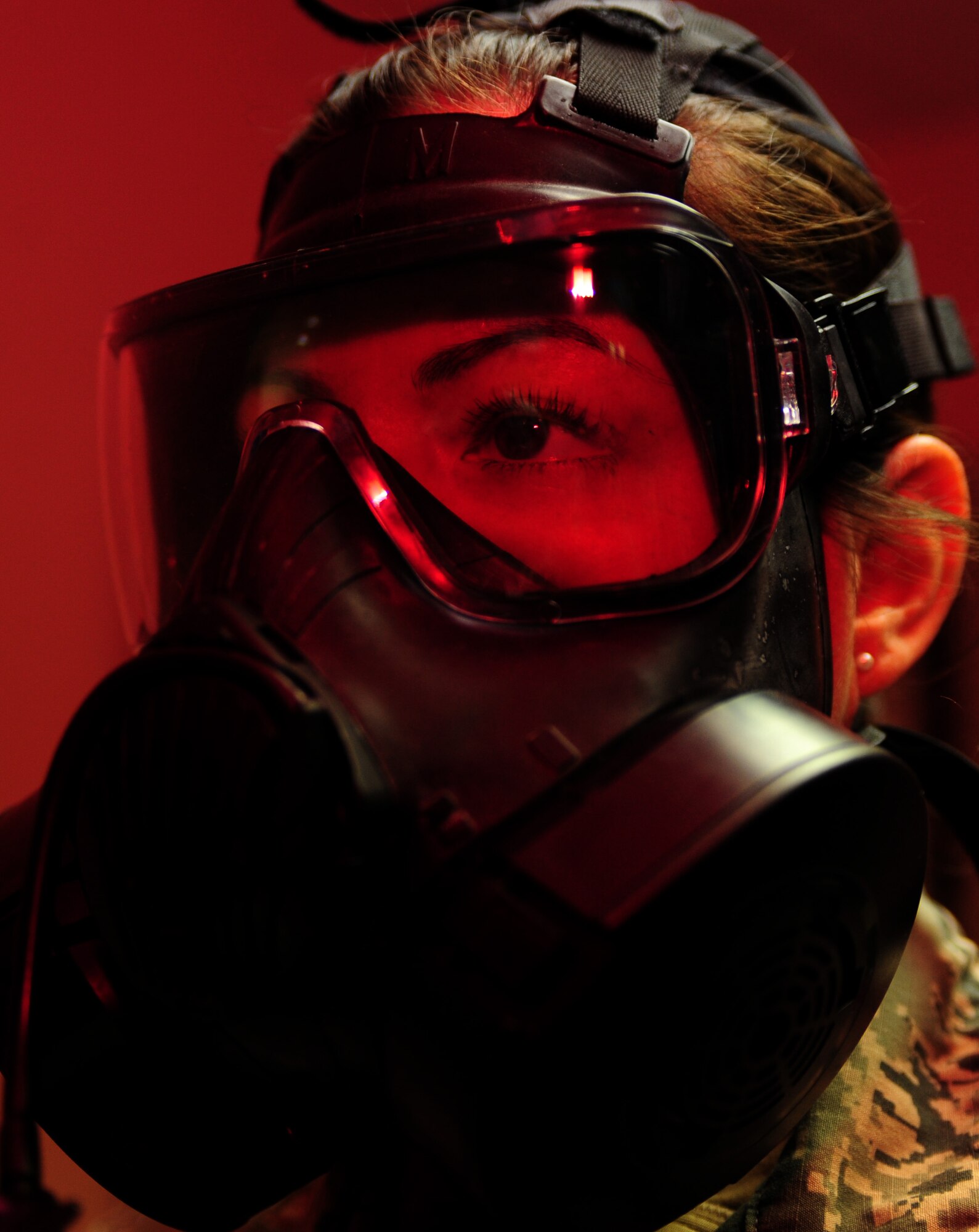 U.S. Air Force Senior Airman Sarah Lowry, 633rd Aerospace Medicine Squadron bioenvironmental engineer technician, dons a gas mask before a fitting at Langley Air Force, Va., Jan. 9, 2015. Gas masks are tested to guarantee masks fit properly and no harmful chemicals can seep through. (U.S. Air Force photo by Airman 1st Class Areca T. Wilson/Released) 