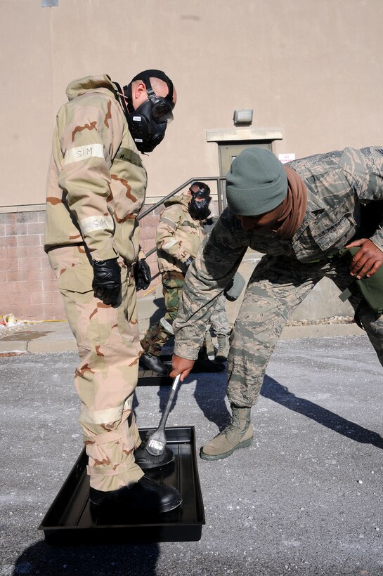 Airman 1st Class Michael Siciliano, left, has his overboots scrubbed while going through a mock contamination control area in Egg Harbor Township, N.J., Jan. 8, 2015. Siciliano is assigned to the New Jersey Air National Guard's 177th Fighter Wing.