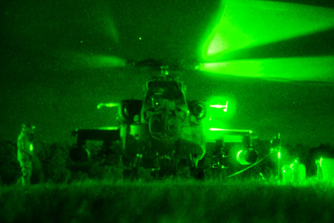 As seen through a night-vision device, soldiers refuel AH-64 Apache helicopters at a forward arming and refueling point during night interdiction training with AH-64 Apache helicopters on McEntire Joint National Guard Base in Eastover, S.C., Jan. 10, 2015.