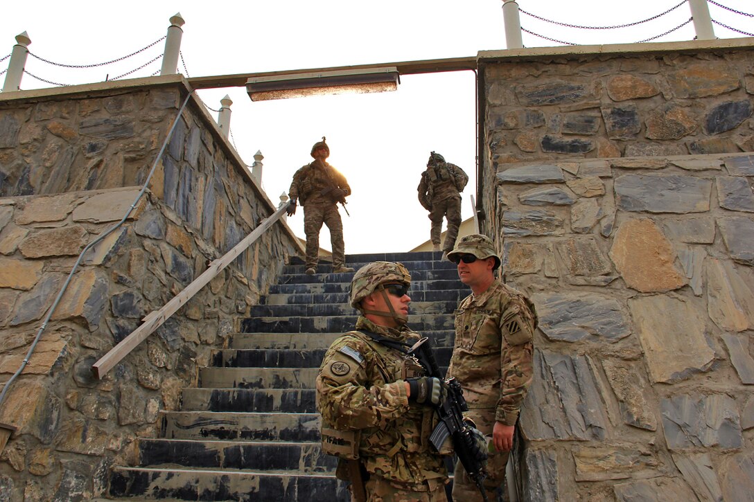 U.S. Army Lt. Col. Matthew Howell, left, and U.S. Army Lt. Col. Pete Fedak, the Train, Advise, Assist Command East  operations officer, wait at the bottom of the rock stairwell during a survey of the Khyber Border Coordination Center near Torkham Gate at the Afghanistan-Pakistan border in Afghanistan's Nangarhar province, Jan. 4, 2015. Howell is commander, military advisory team and Fedak is an operation officer assigned to Train, Advise, Assist Command East security force.