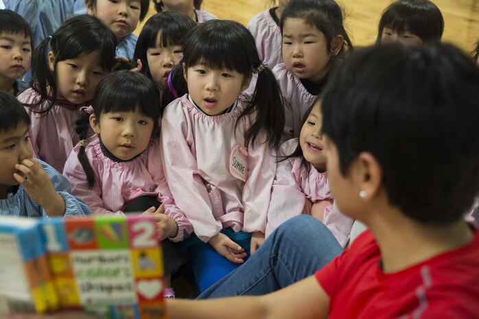 Students from Josho Hoikuen in Iwakuni City, Japan, listen to a service member from Marine Corps Air Station Iwakuni read English books to them during a community relations preschool event hosted by the Marine Memorial Chapel, Jan. 13, 2015. Volunteers used picture books to teach the children English.