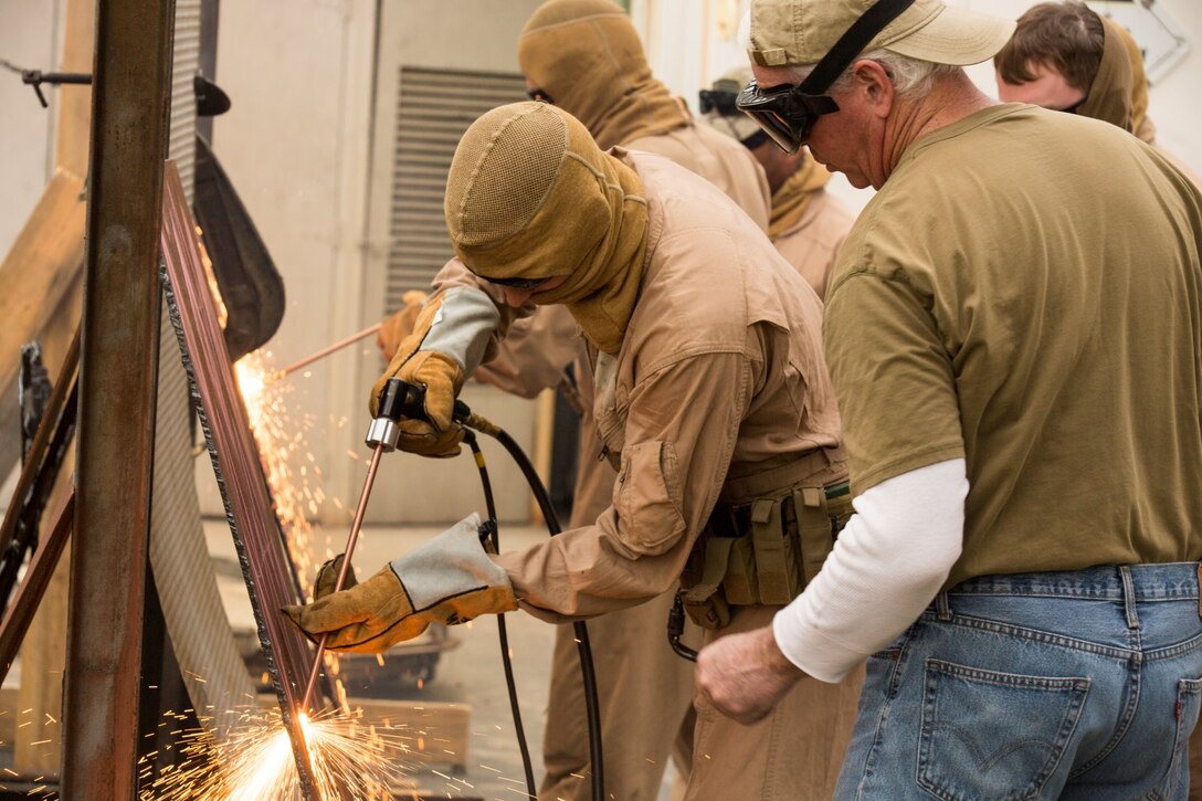 Mr. Tom Joos, with Broco Tactical Systems, teaches breaching techniques to U.S. Marines with the 15th Marine Expeditionary Unit's Maritime Raid Force during maritime interoperability training at Stu Segall production studio, San Diego, Calif., Jan. 9, 2015. MIT prepares the 15th MEU's MRF for their upcoming deployment by enhancing their combat skills, and teaching them techniques for boarding vessels. (U.S. Marine Corps photo by Sgt. Jamean Berry/Released)