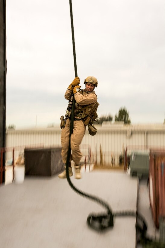 U.S. Marine Sgt. Nick Bardsley with the 15th Marine Expeditionary Unit's Maritime Raid Force fast-ropes during maritime interoperability training at Stu Segall production studio, San Diego, Calif., Jan. 9, 2015. MIT prepares the 15th MEU's MRF for their upcoming deployment by enhancing their combat skills, and teaching them techniques for boarding vessels. (U.S. Marine Corps photo by Sgt. Jamean Berry/Released)