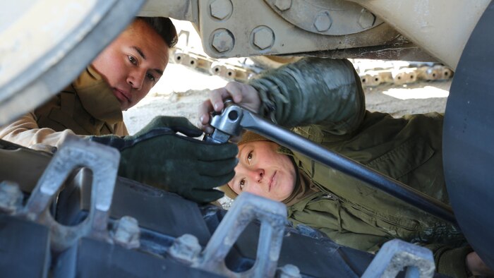 Cpl. Nick A. Buenviaje, left, tank gunner, and Sgt. Michelle A. Svec, tank crewman, both with Tank Platoon, Company B, Ground Combat Element Integrated Task Force, tighten a bolt on the track pad of an M1A1 Abrams tank during vehicle maintenance at Range SR-10, Marine Corps Base Camp Lejeune, North Carolina, Jan. 9, 2015. Marines with Tank Platoon conducted offensive and defensive engagements to prepare for an upcoming assessment at Marine Corps Air Ground Combat Center Twentynine Palms, California. From October 2014 to July 2015, the GCEITF will conduct individual and collective level skills training in designated ground combat arms occupational specialties in order to facilitate the standards based assessment of the physical performance of Marines in a simulated operating environment performing specific ground combat arms tasks. 