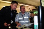 Amgalan Jambalsuren, captain of the Mongolia Metropolitan Police Department, learns about plans management from George Mayberry, a plans management intelligence specialist for Alaska Department Homeland Security and Emergency Management, during the Vigilant Guard exercise. Vigilant Guard is a premiere joint training exercise designed to increase interoperability between federal, state and local volunteer agencies in case of a disaster.