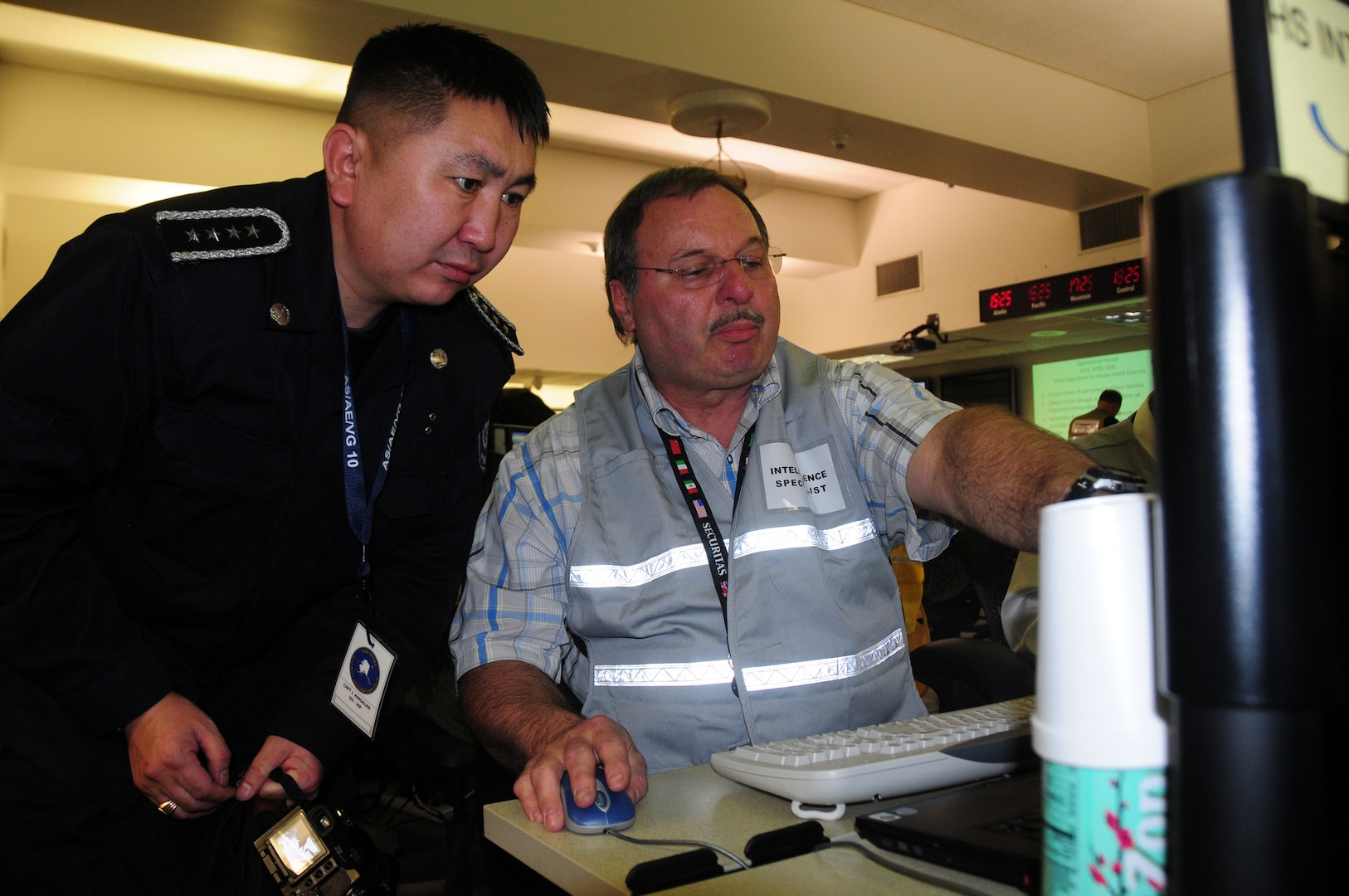 Amgalan Jambalsuren, captain of the Mongolia Metropolitan Police Department, learns about plans management from George Mayberry, a plans management intelligence specialist for Alaska Department Homeland Security and Emergency Management, during the Vigilant Guard exercise. Vigilant Guard is a premiere joint training exercise designed to increase interoperability between federal, state and local volunteer agencies in case of a disaster.