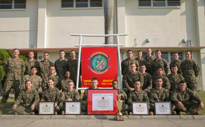 Marines with Headquarters Regiment stand with their maintenance readiness awards from all four quarters and the overall 2014 fiscal year on Camp Kinser, Dec. 31. Headquarters Regiment, 3rd Marine Logistics Group, III Marine Expeditionary Force maintained an overall maintenance readiness of 90% or higher throughout the entire year of 2014. “My success comes from the success of my Marines,” said Col. Edmund J. Bowen, the regiment’s commanding officer, from Staten Island, New York. (U.S. Marine Corps photo by Lance Cpl. William Hester/ Released)