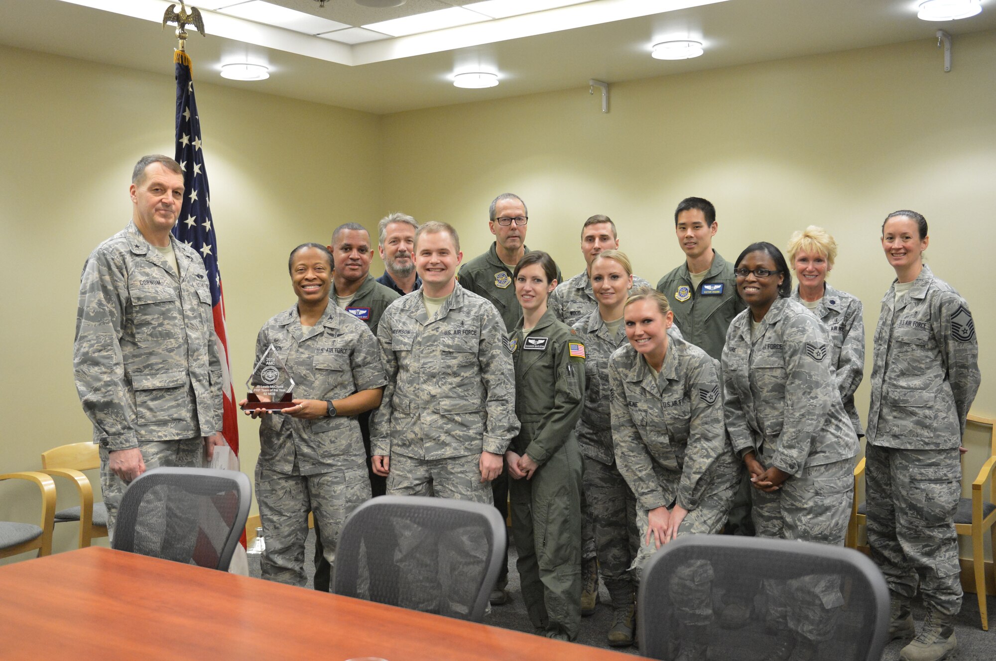 Brig. Gen. Kory Cornum (left), Air Mobility Command surgeon general, presents members of the 62nd Medical Squadron with their award Jan. 14, 2015, at Joint Base Lewis-McChord, Wash. The squadron received the 2014 AMC Outstanding Personnel Reliability Program Team of the Year award. (U.S. Air Force photo/Senior Airman Rebecca Blossom)