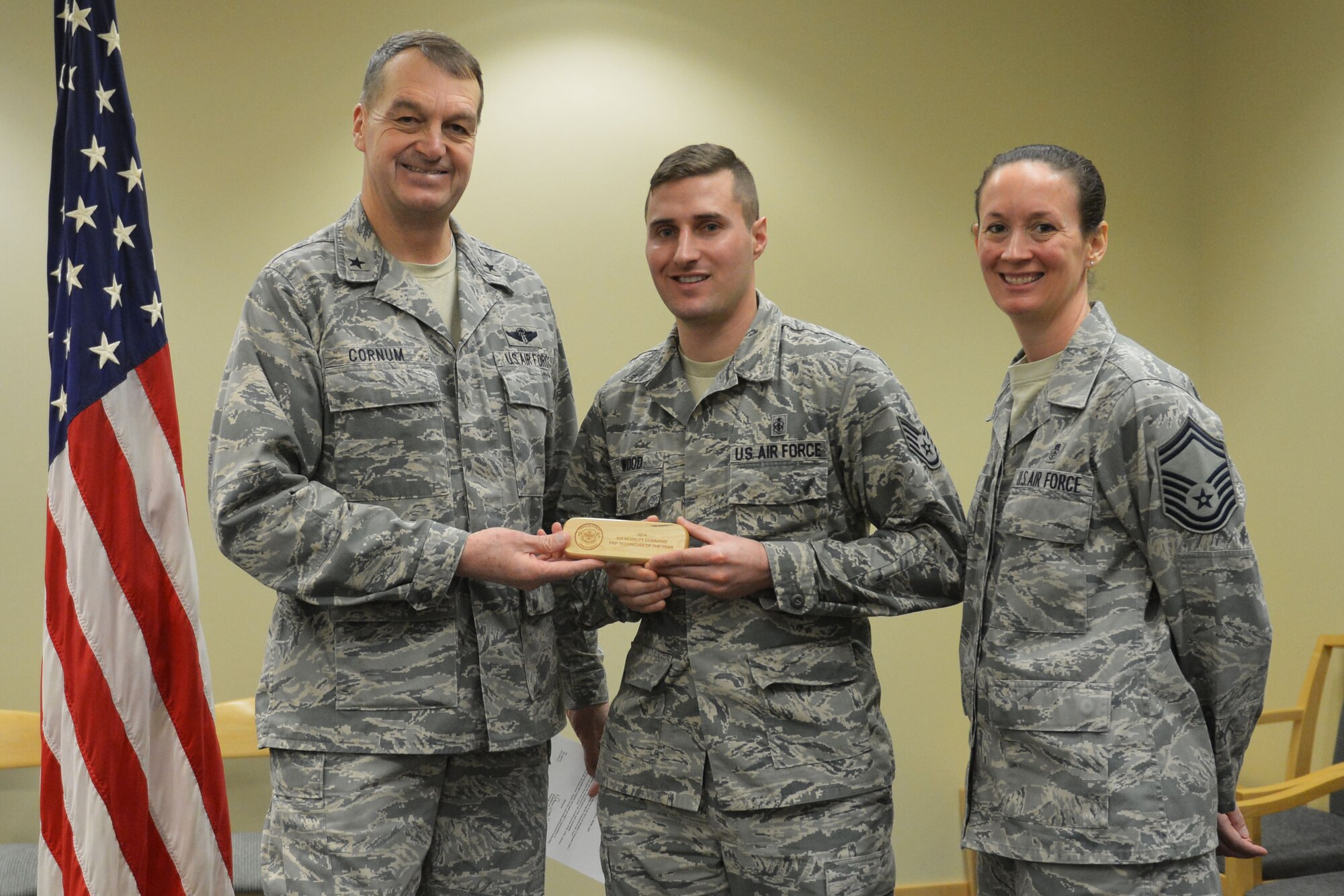 Brig. Gen. Kory Cornum (left), Air Mobility Command surgeon general, awards Staff Sgt. Barry Wood (center), 62nd Medical Squadron NCO in charge of records and reception, with the 2014 AMC Outstanding Personnel Reliability Program Technician of the Year award Jan.14, 2015, at Joint Base Lewis-McChord, Wash. Cornum visited the 62nd MDS to recognize both Wood and the squadron. (U.S. Air Force photo/Senior Airman Rebecca Blossom)