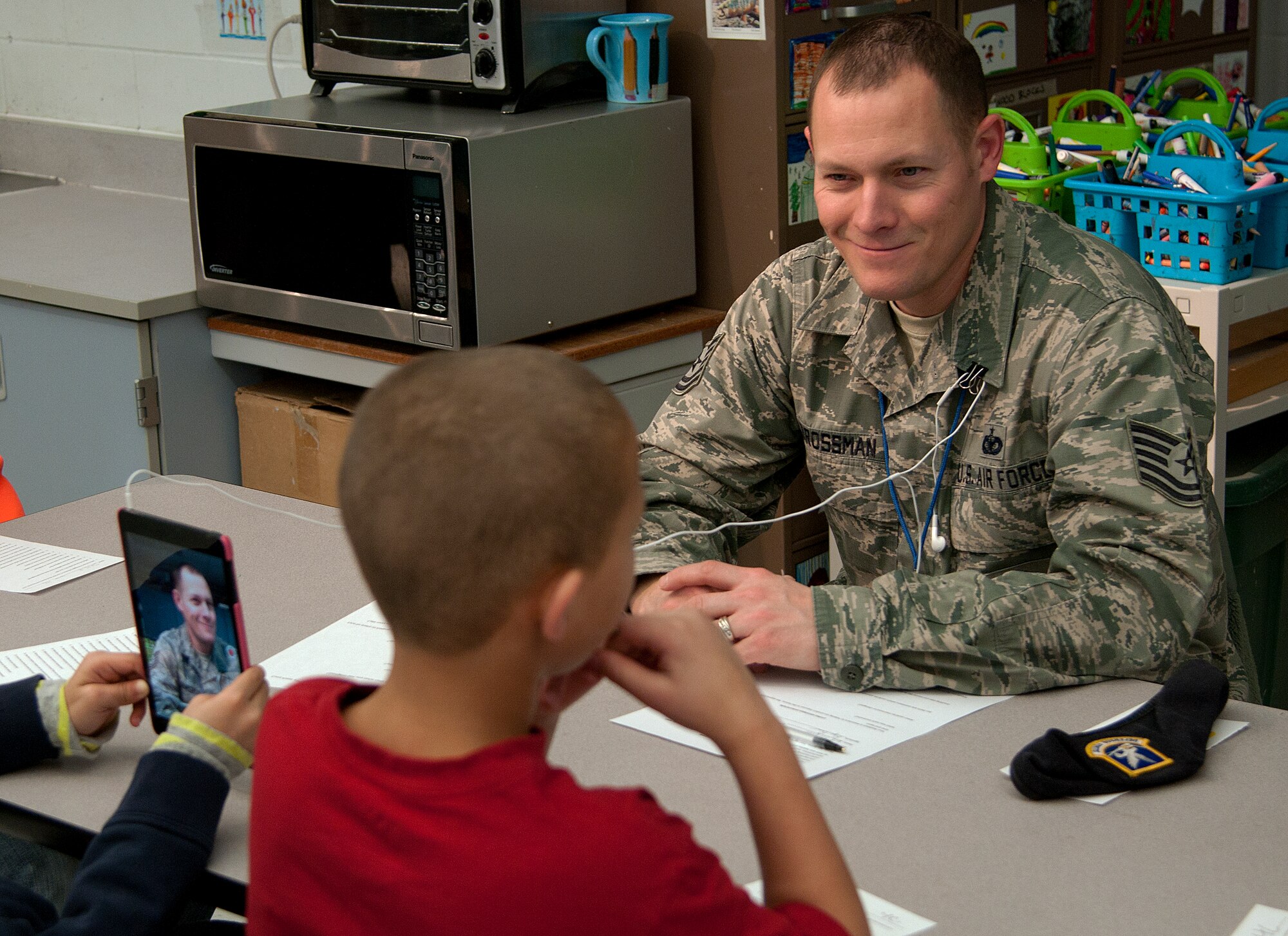 Tech. Sgt. Bryan Brossman, 90th Security Support Squadron missile security control NCO-in-charge at F.E. Warren Air Force Base, Wyo., listens as fourth grade students ask him questions about his life Jan. 13, 2015, at Freedom Elementary School. The students had over an hour to ask as many questions as they wanted. (U.S. Air Force photo/Airman 1st Class Brandon Valle)